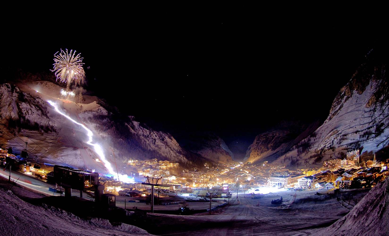 Val d'Isère village illuminated at night with snow-covered rooftops and alpine charm