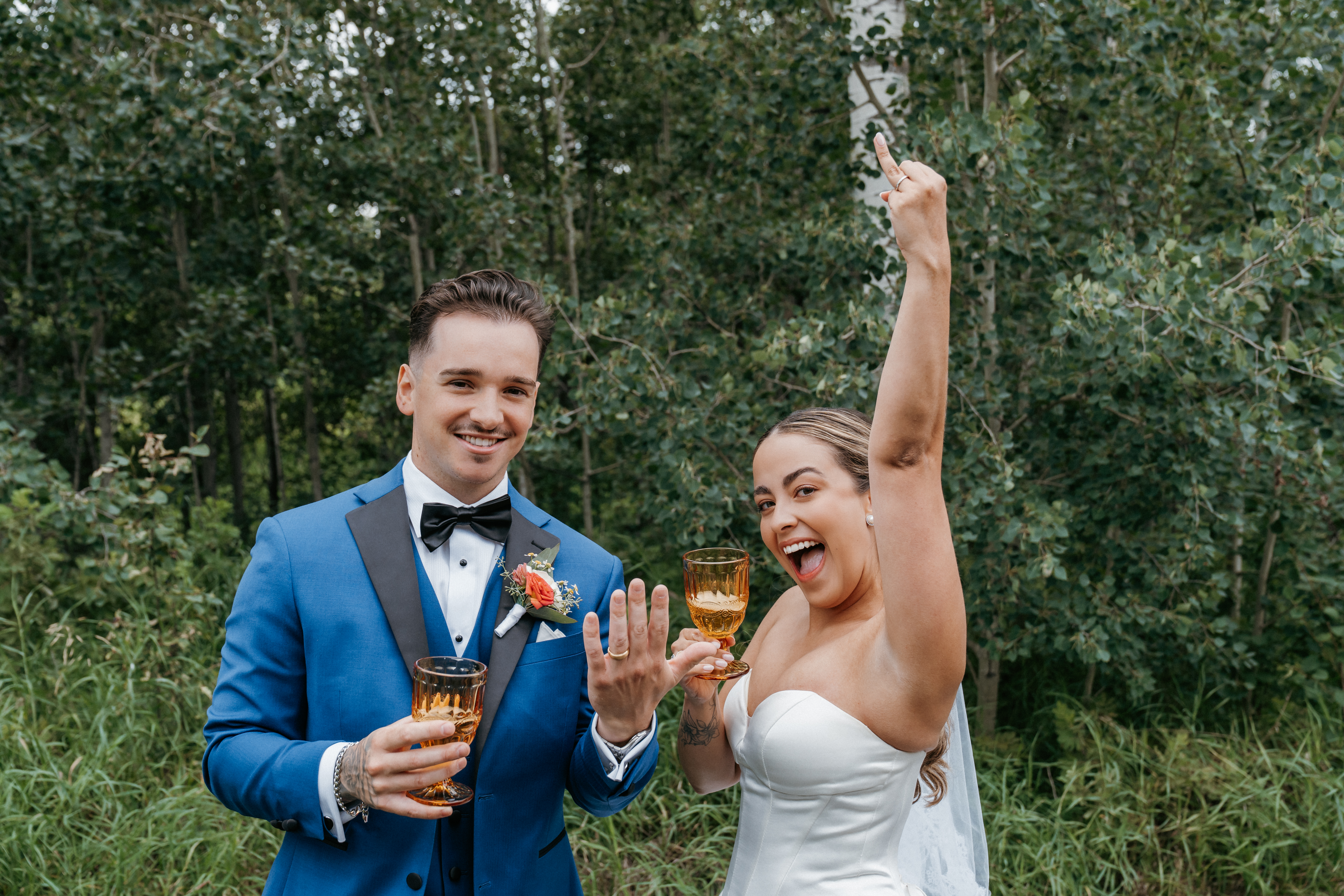 Newlyweds celebrating with champagne and showing rings