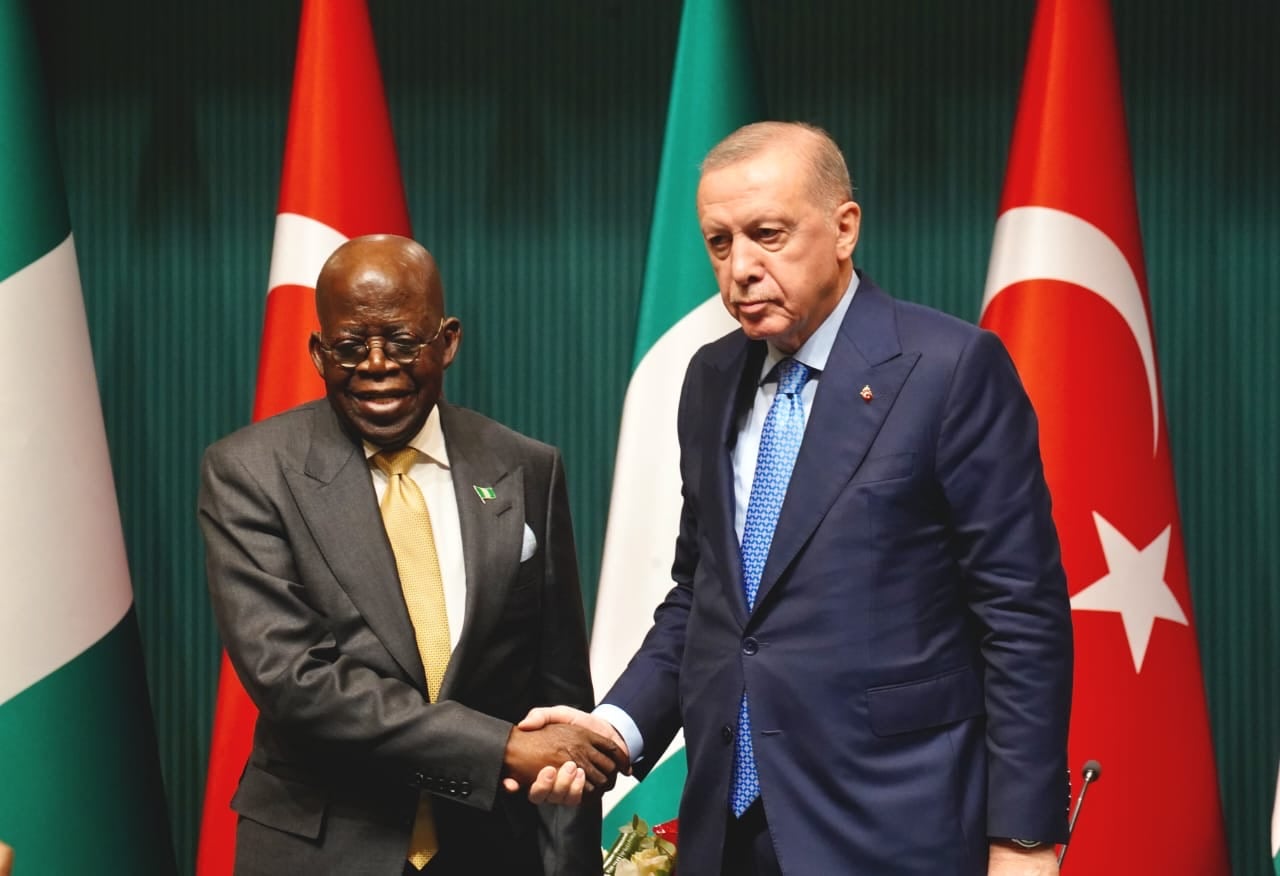 President Bola Ahmed Tinubu and President Recep Tayyip Erdoğan shake hands before the Nigerian and Turkish flags in Ankara