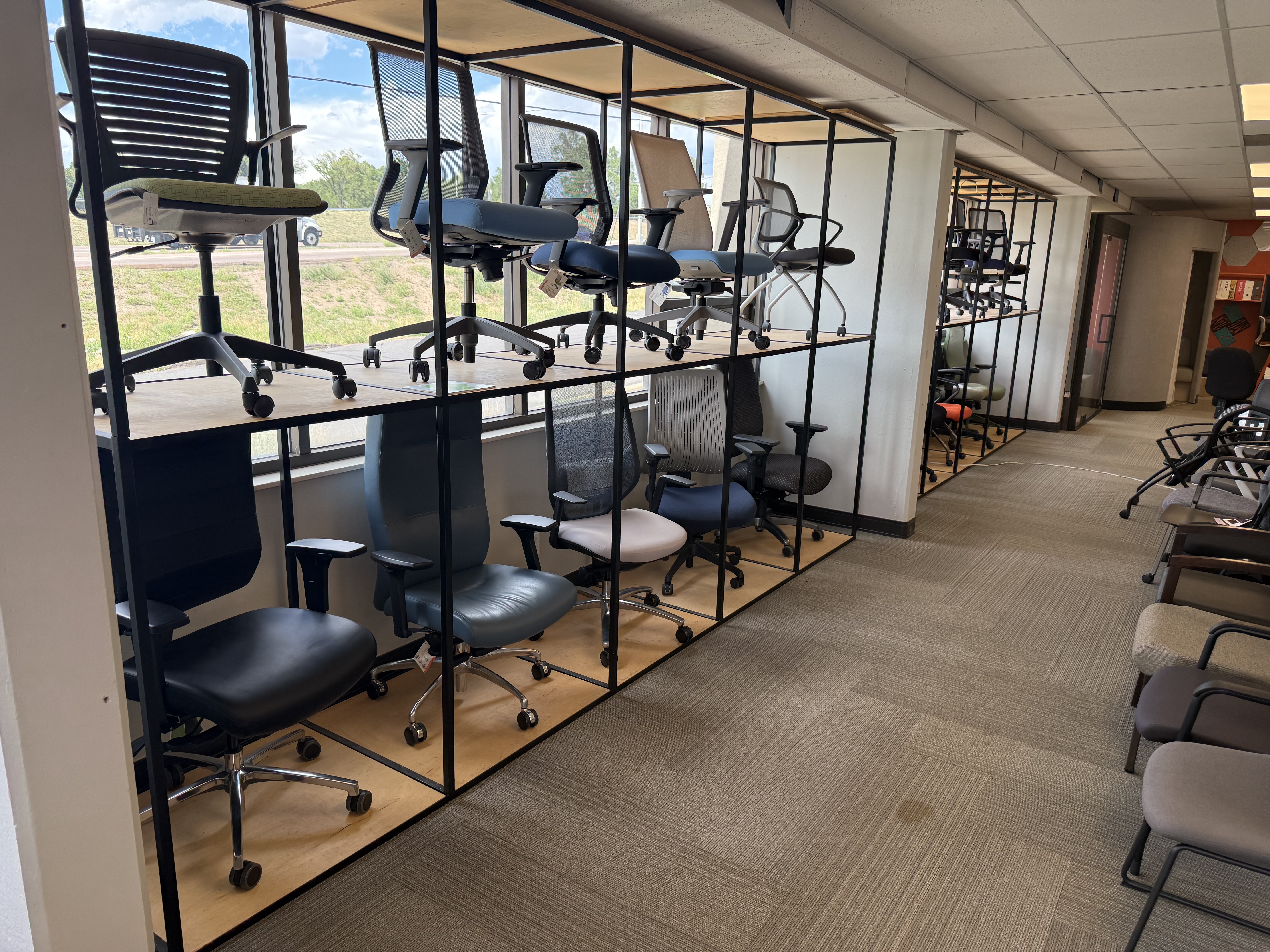 Wall display showcasing a wide selection of ergonomic office chairs