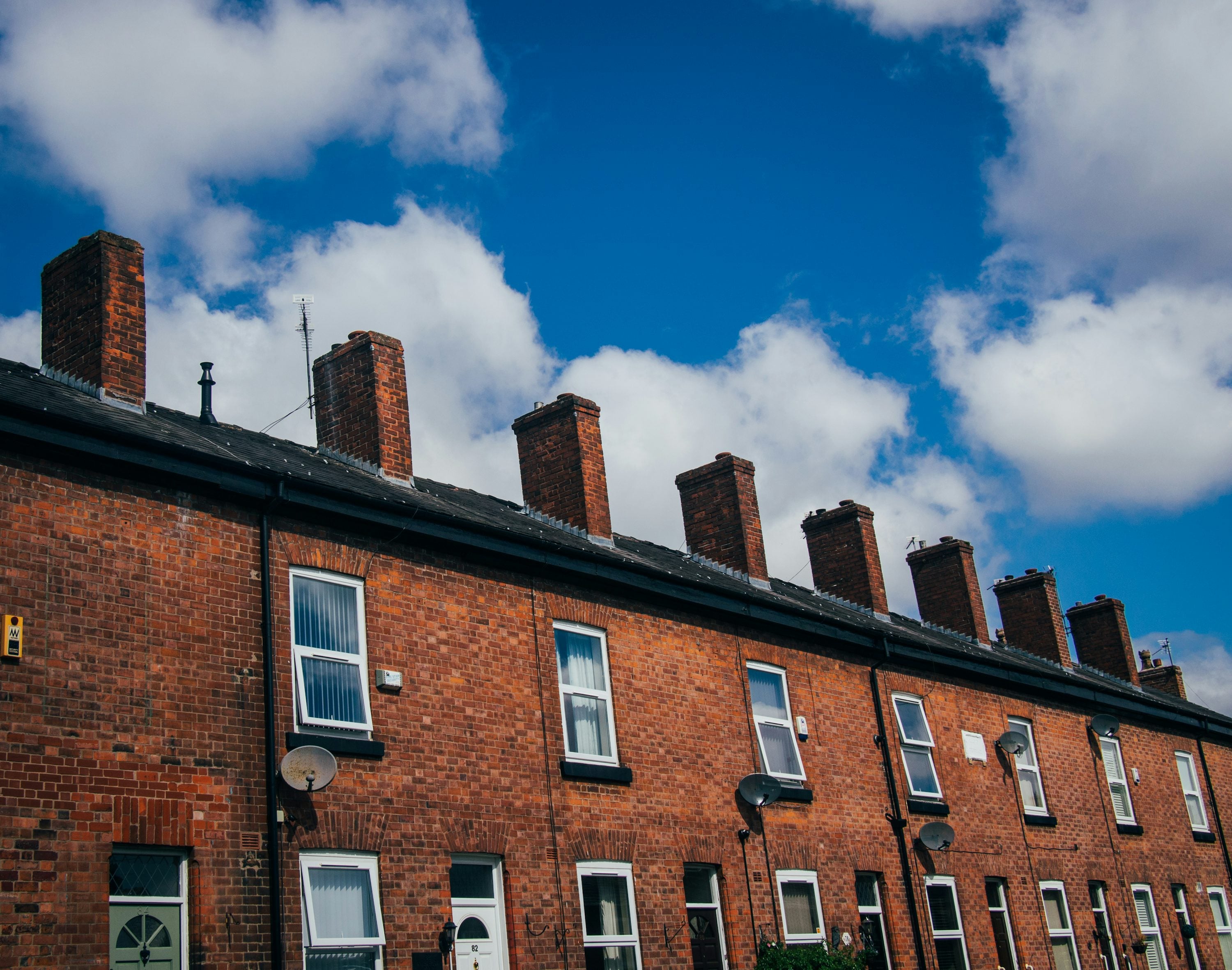 Row of British red-brick terraced houses with chimney stacks
