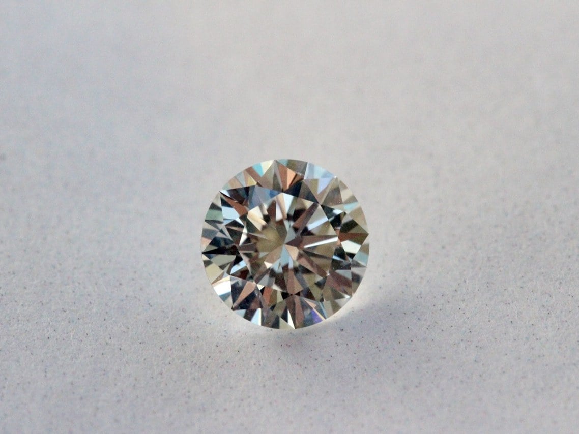 Brilliant-cut clear diamond sparkling against dark background