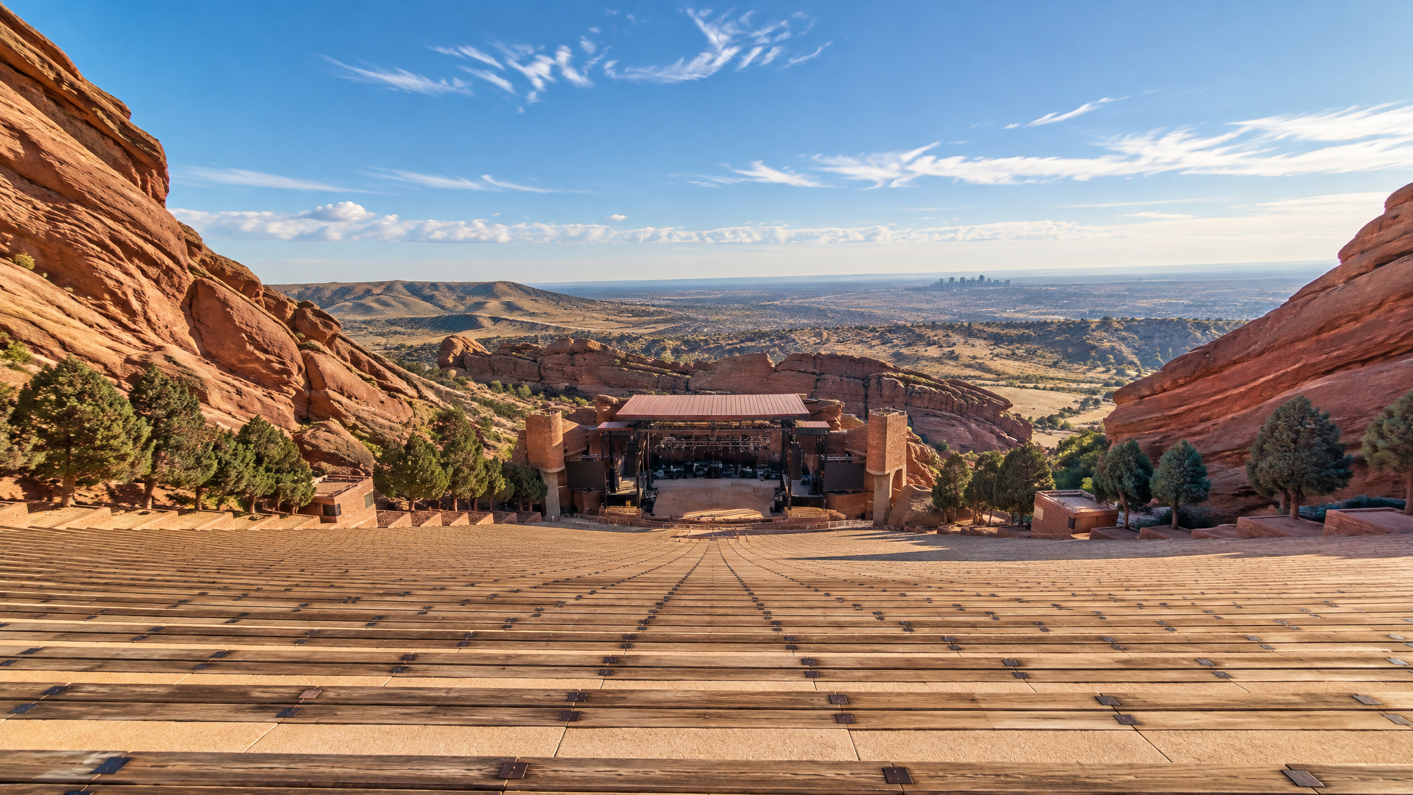 The view from the top of Red Rocks Amphitheatre in daylight, looking down the stone rows toward the distant stage