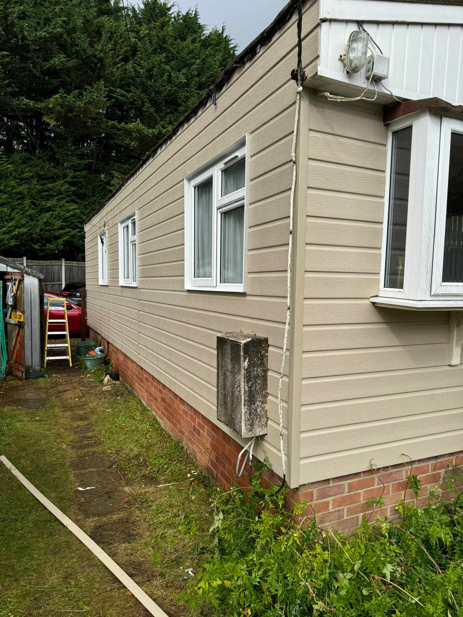 Rear view of park home showing completed cladding with windows and utility connections