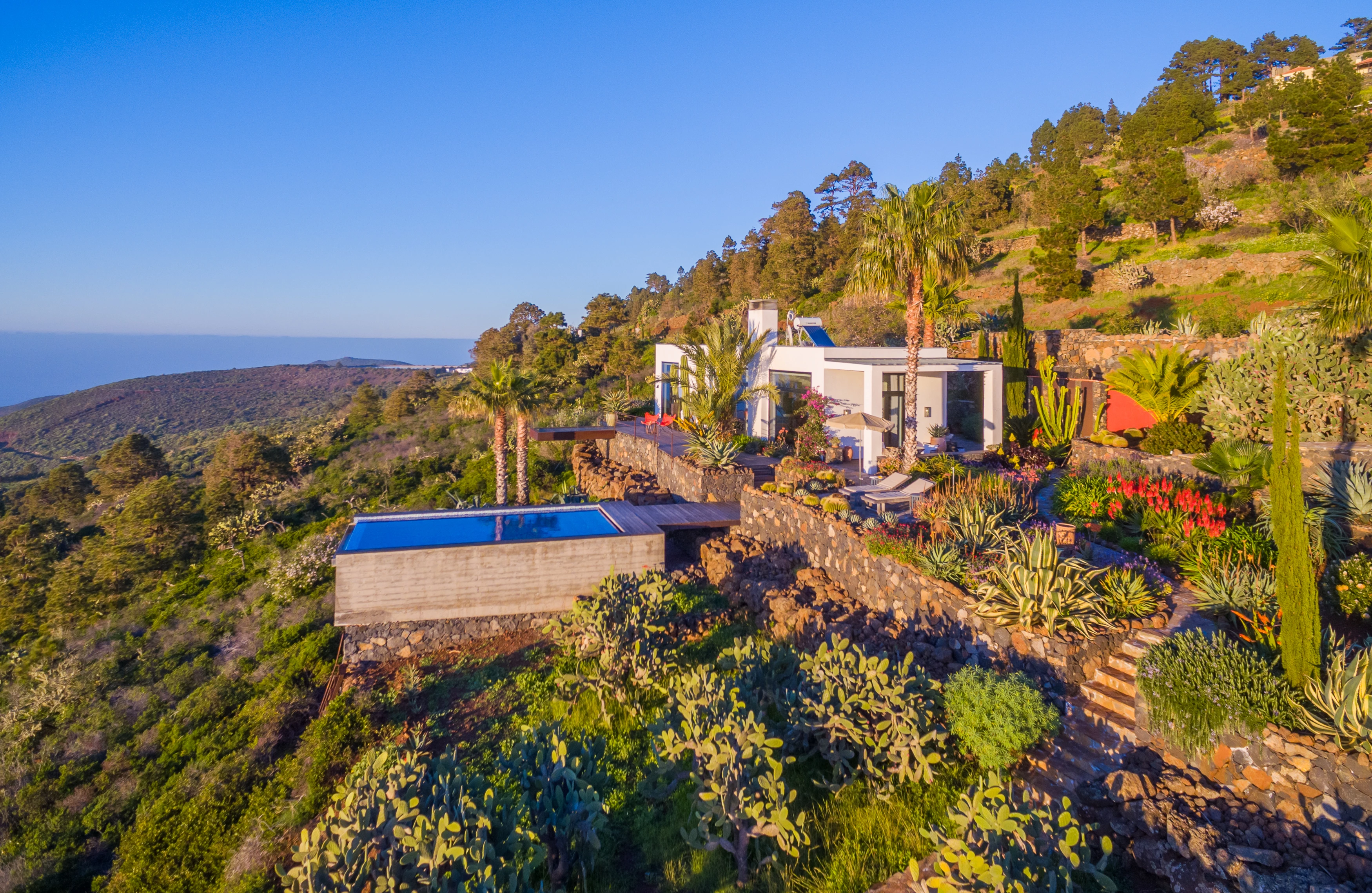 Aerial view of villa with infinity pool on hillside