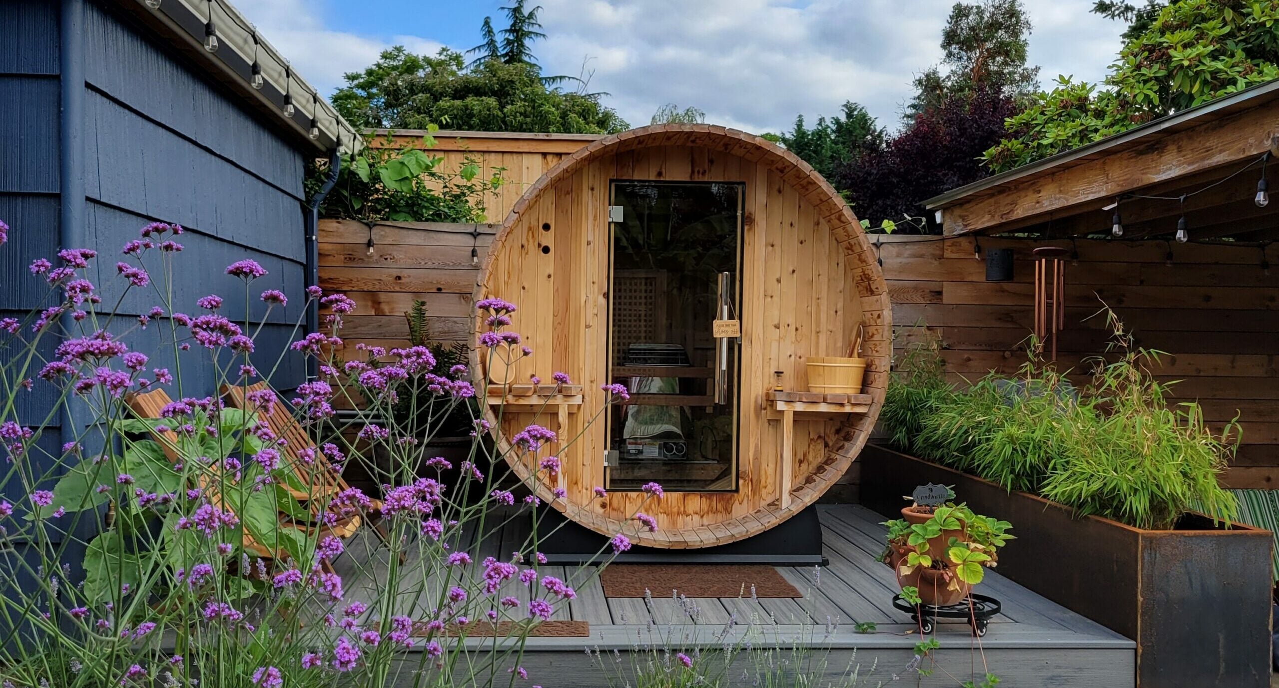 Outdoor barrel sauna in a beautiful backyard landscape setting