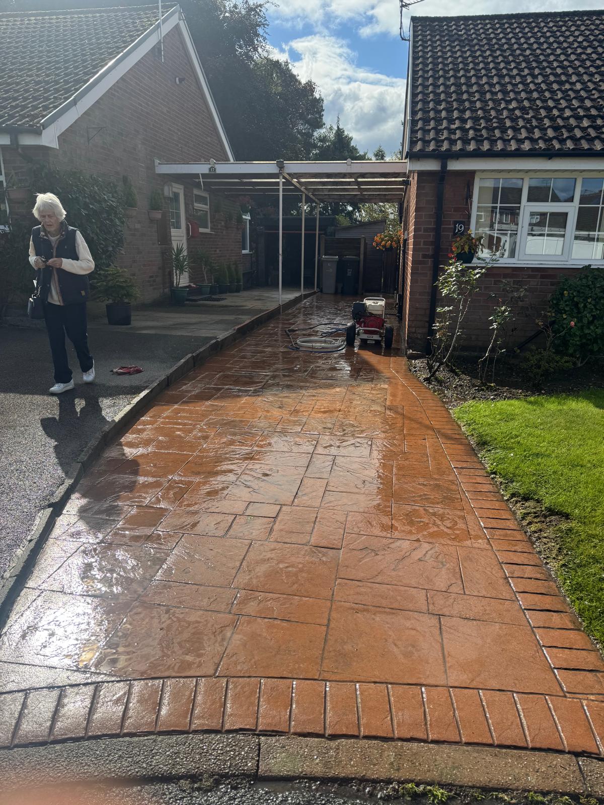 Finished stamped concrete driveway - gleaming wet with pattern fully visible