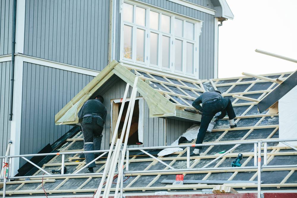 New roof being installed with workers on scaffolding