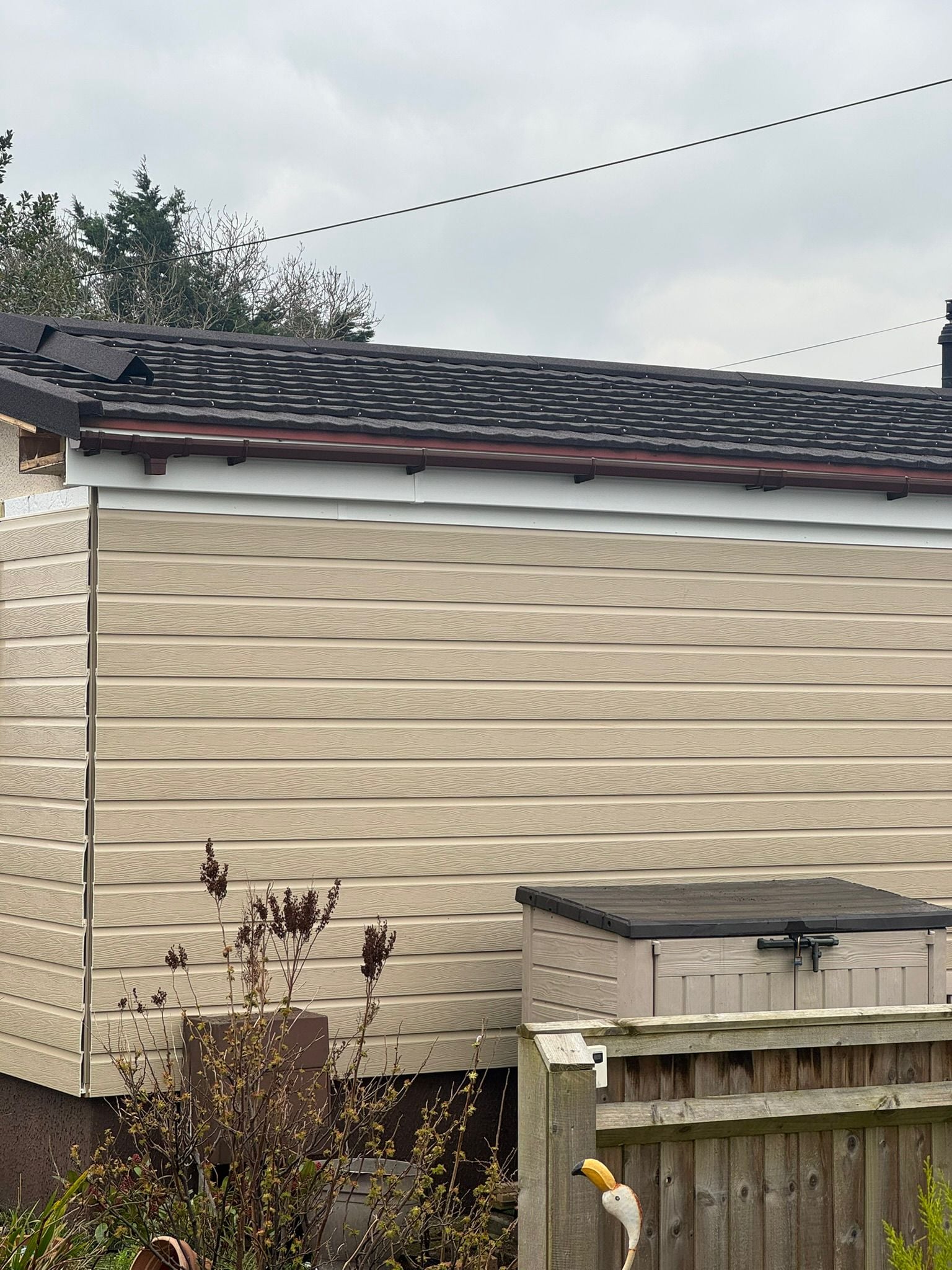 Rear view of park home with new cladding panels and dark roof tiles