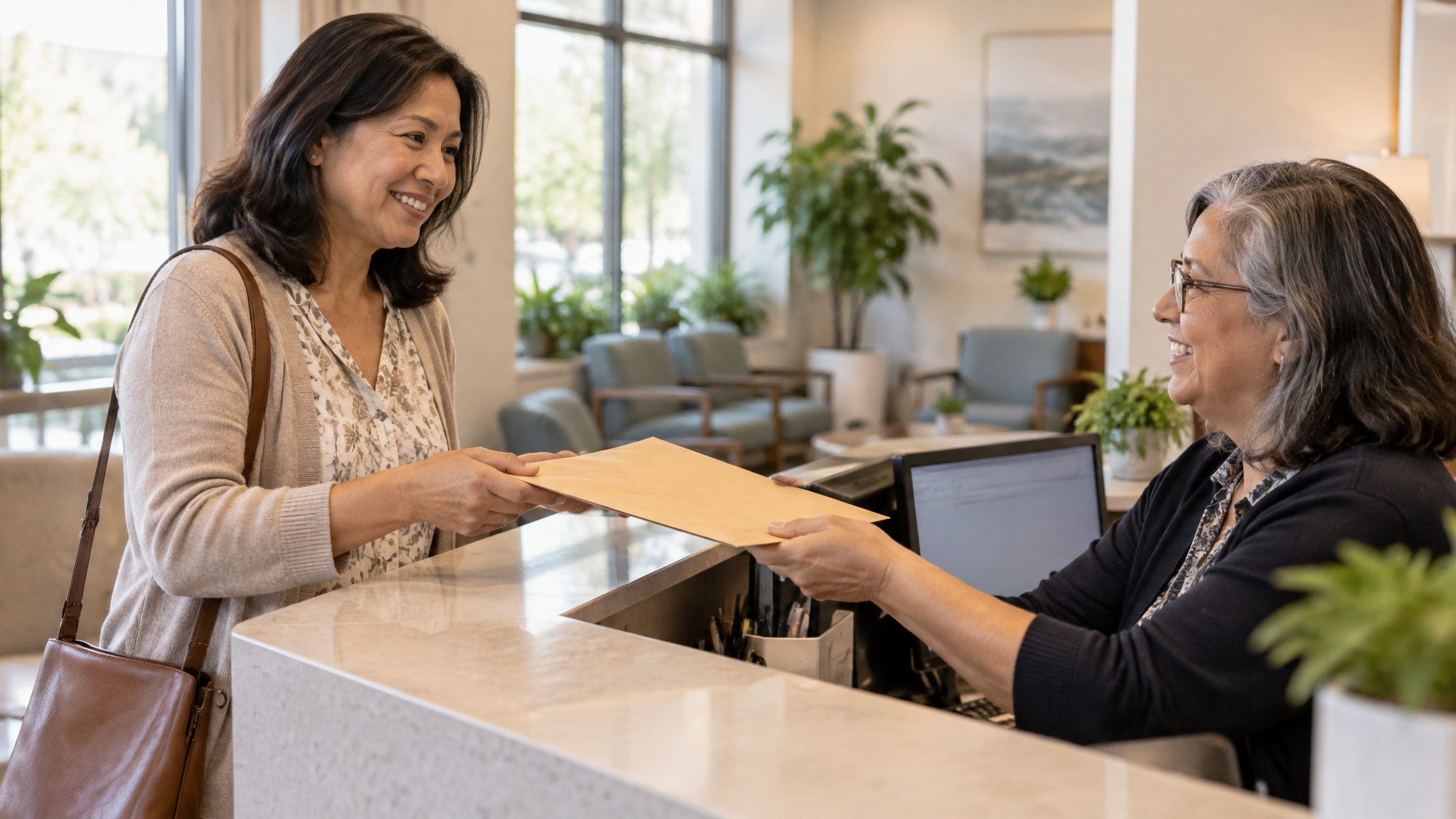A woman veteran in her late forties receiving a plain envelope of medical records from a woman receptionist at a clinic desk
