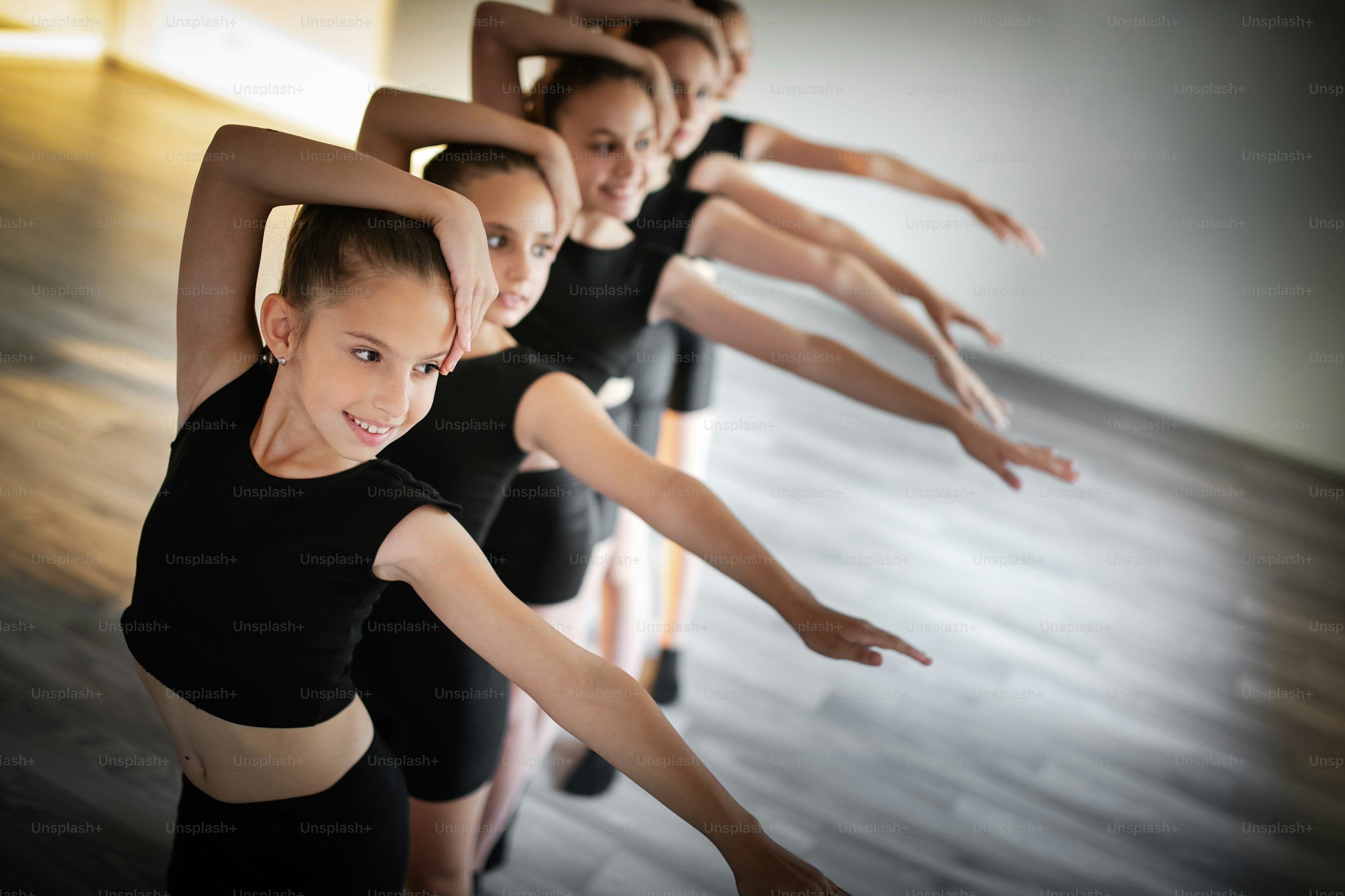 Sarah leading a dance workshop with a group of students in a bright studio