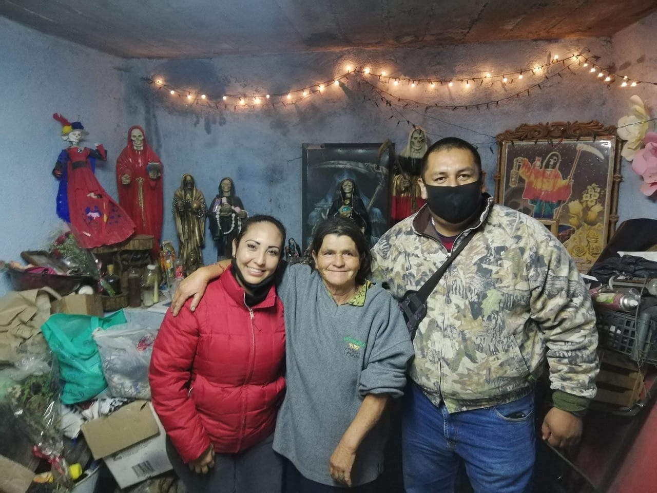 Martha Molina con visitantes en su altar de bienestar