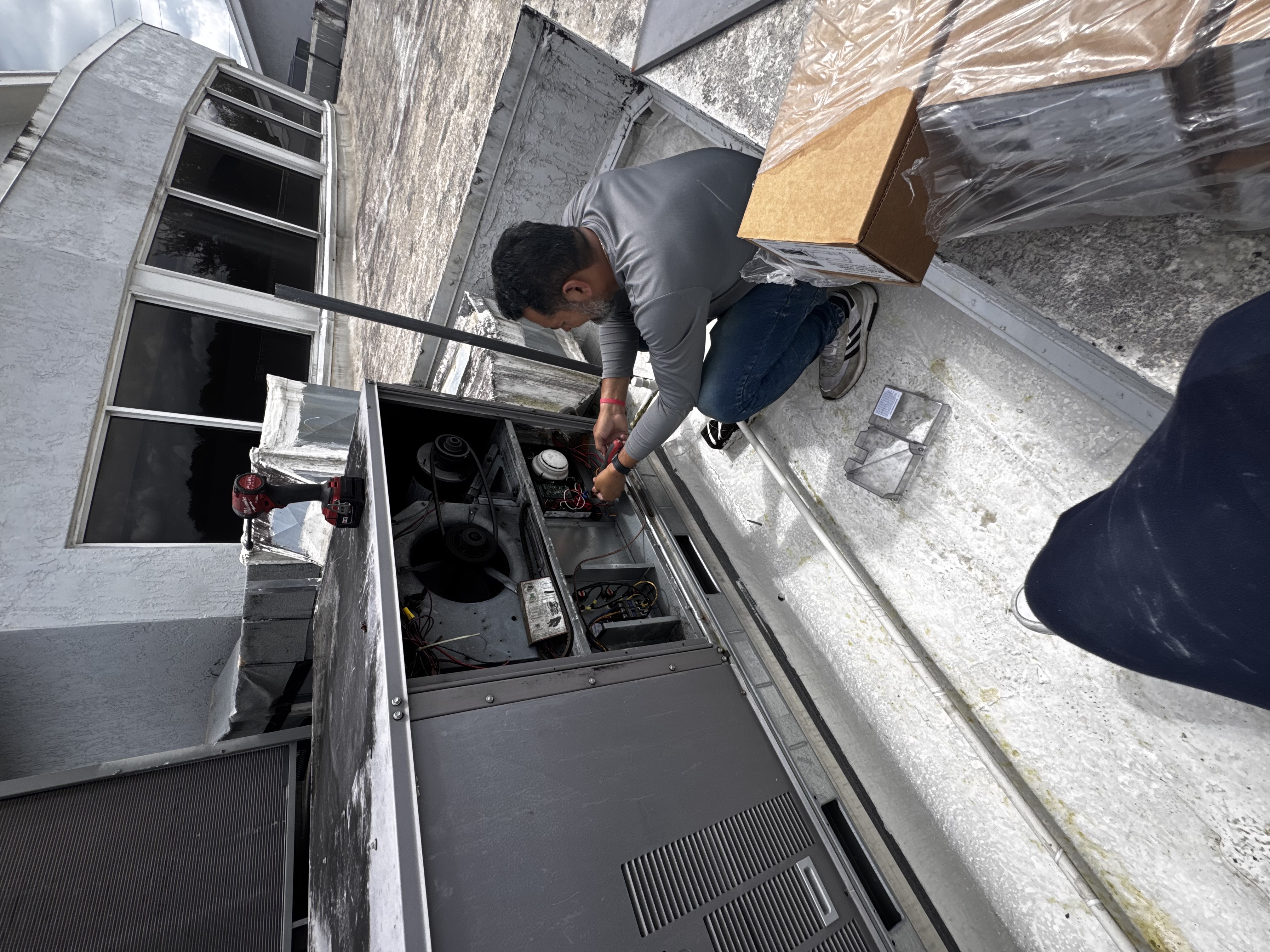 Weather Control HVAC technician servicing rooftop commercial unit