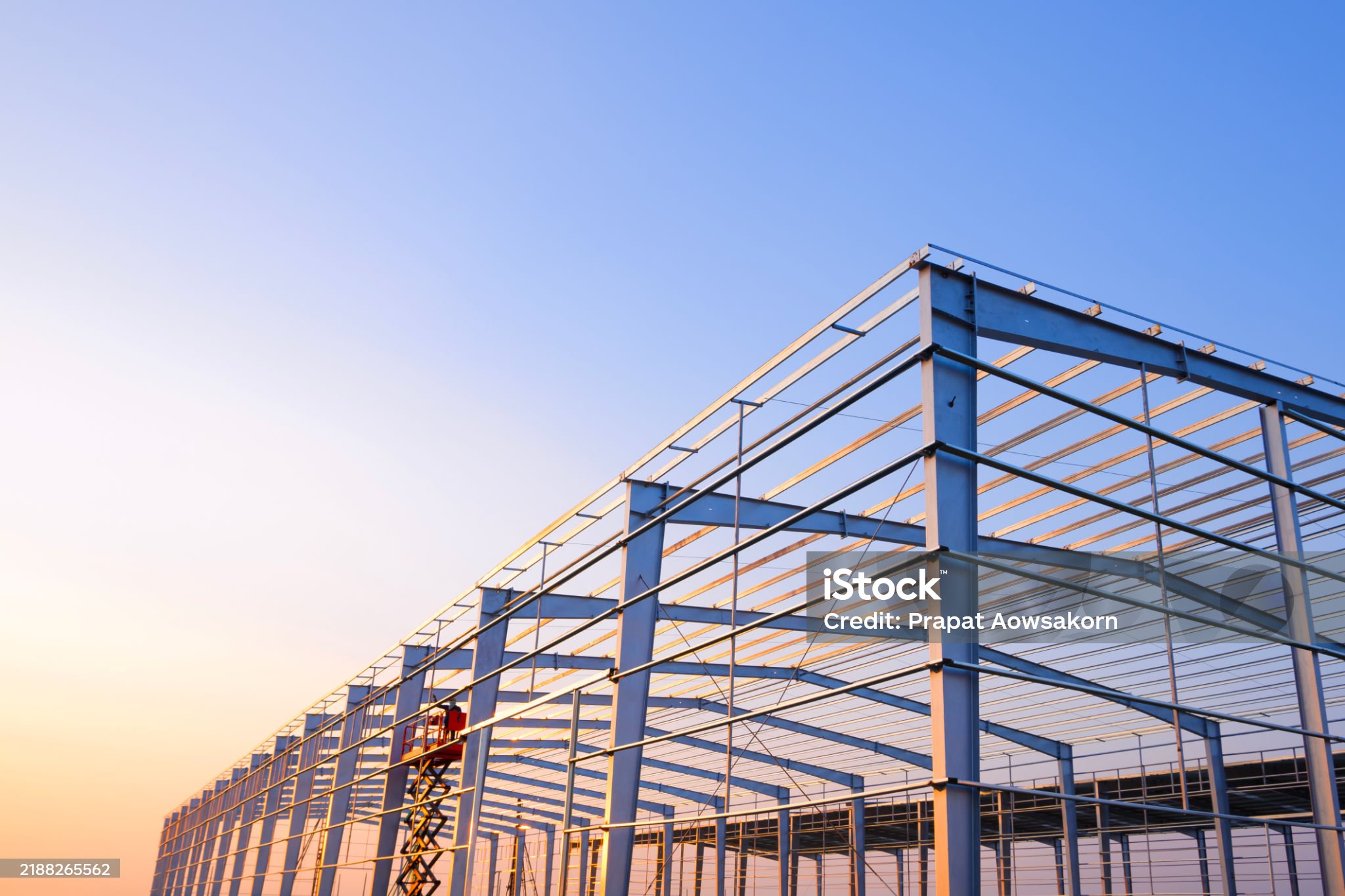 Steel frame warehouse construction at sunset