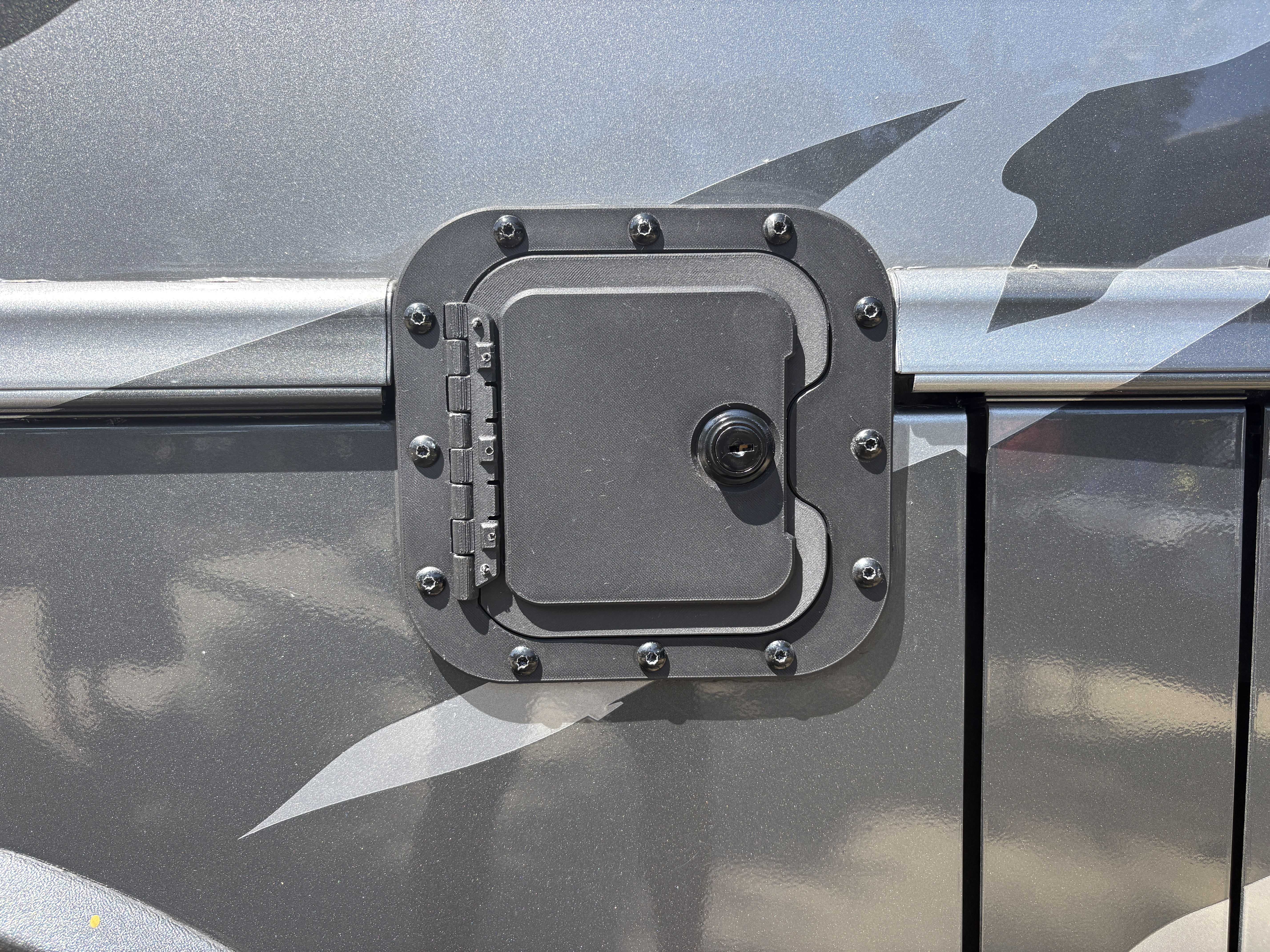 Close-up of The Work Truck Fuel Vault locking fuel door installed on a commercial work truck
