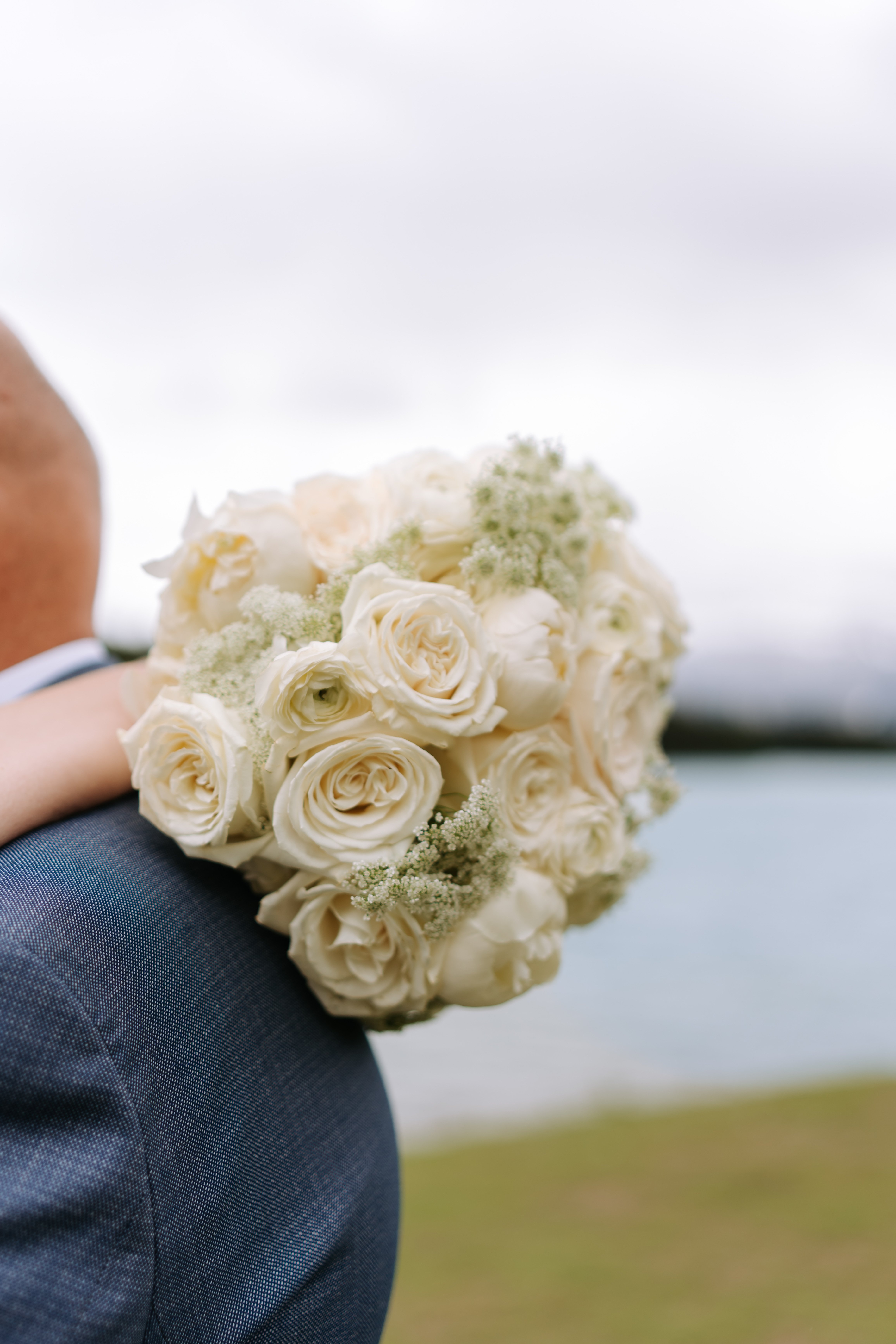 Couple embracing at mountain lake with bouquet