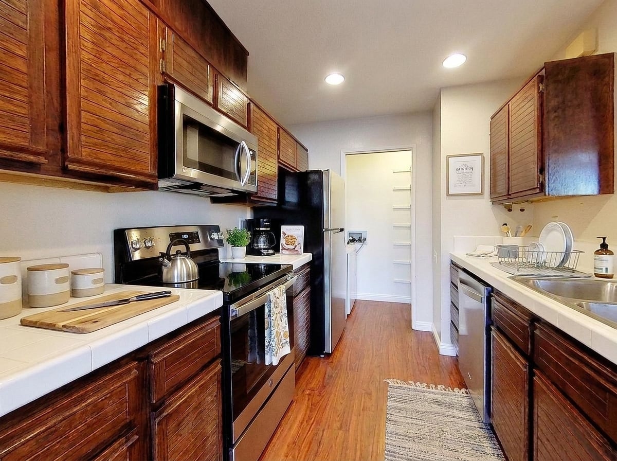 Galley kitchen with stainless steel appliances and laundry area