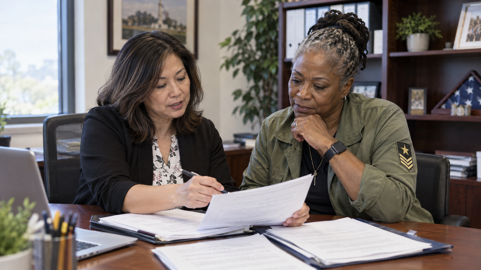 A woman accredited claims agent and a woman veteran reviewing her appeal paperwork together