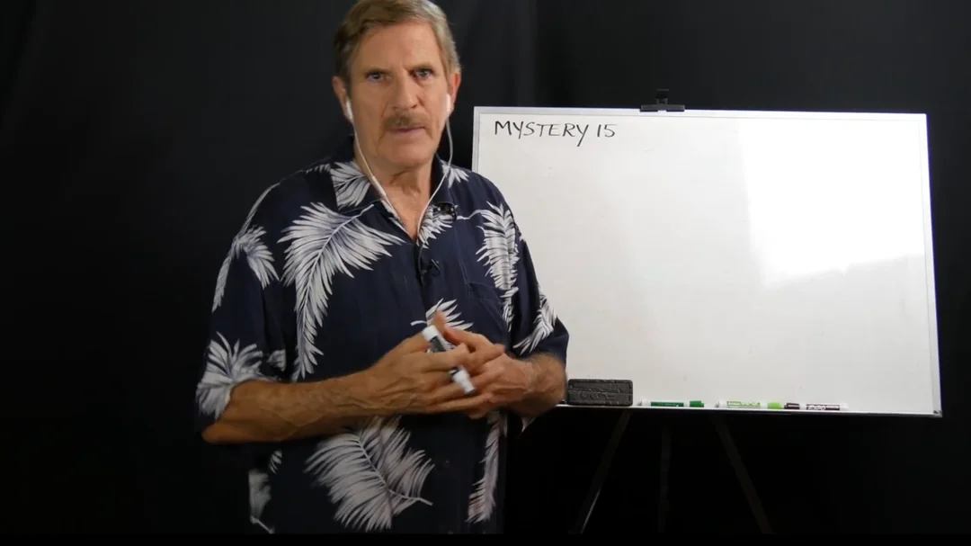 Dick standing at a whiteboard during a remote viewing target briefing session