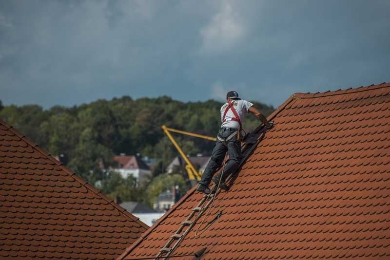 Roofer fixing damaged tiles