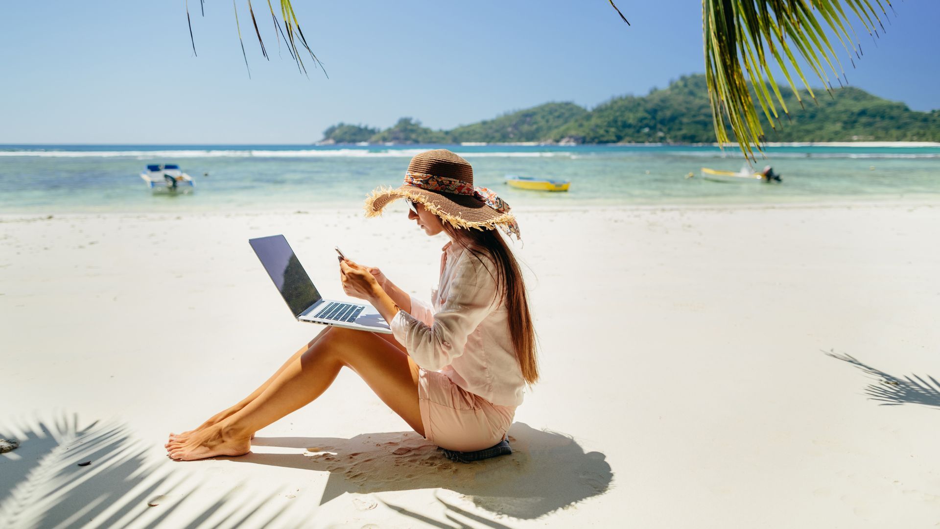 Entrepreneur working from luxury beach location with laptop