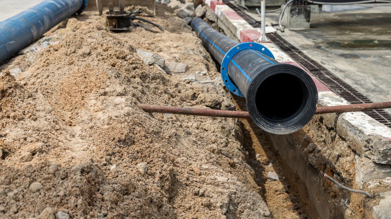 Large drainage pipe installation in open trench on civil construction site