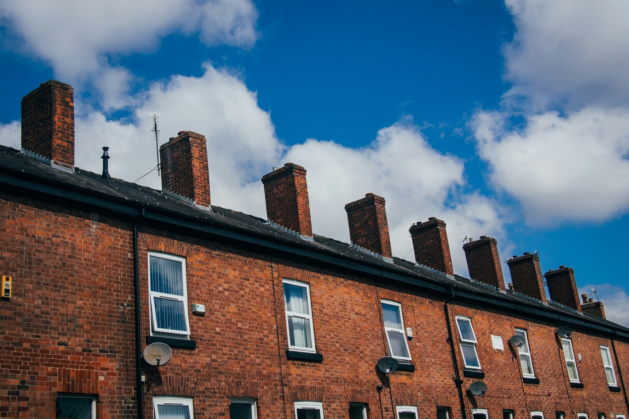 Brick terrace roofline with black fascias and guttering