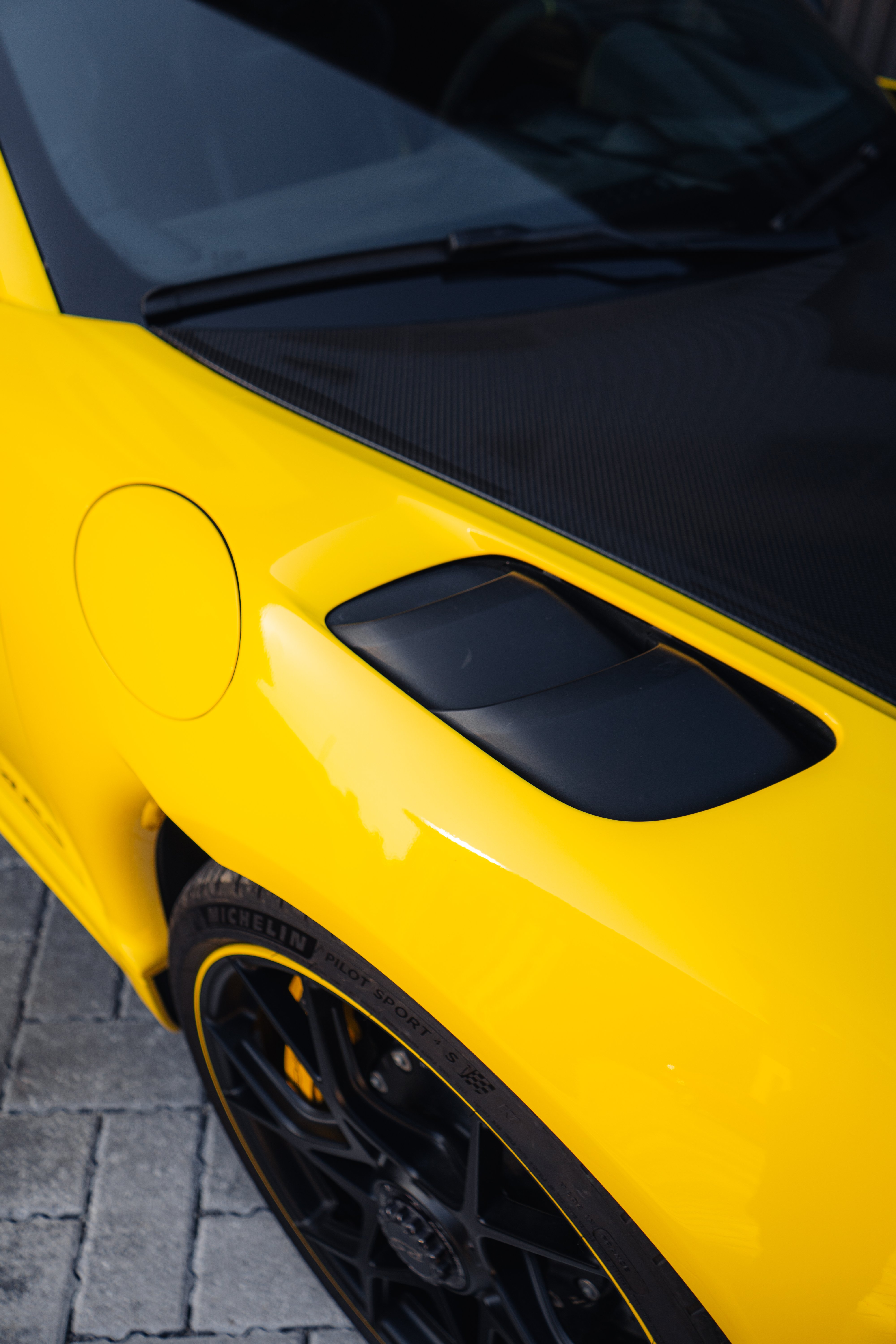 Porsche GT4 RS carbon fiber Weissach hood NACA duct and center-lock wheel detail