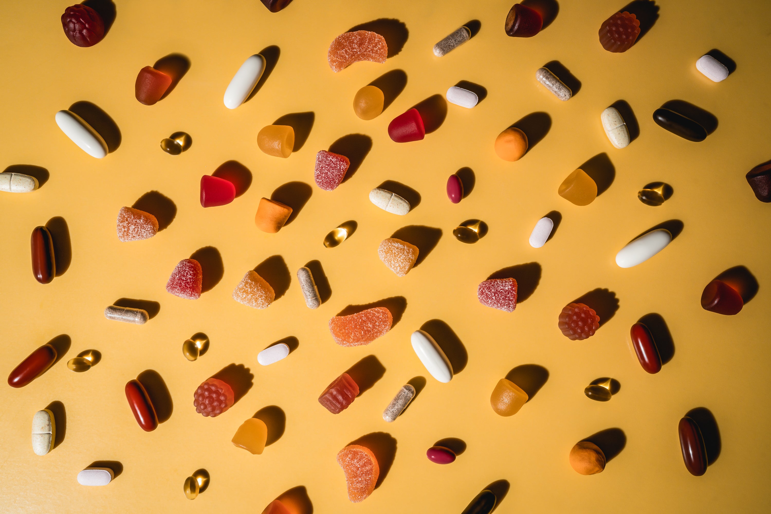 Porównanie form kreatyny - żelki, proszek i kapsułki na stole