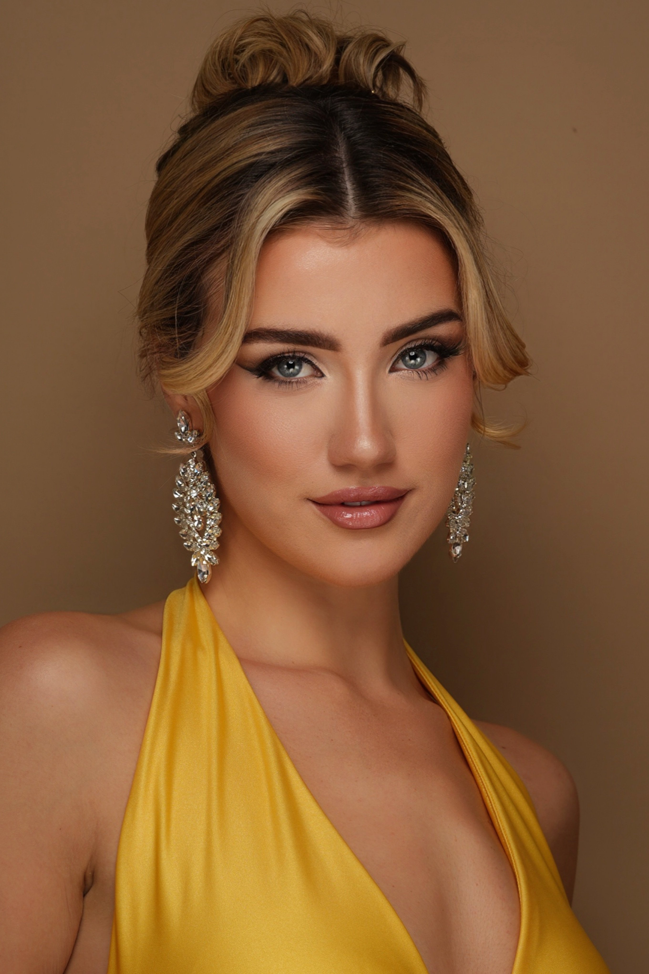 Stunning headshot in gold satin halter dress with diamond earrings