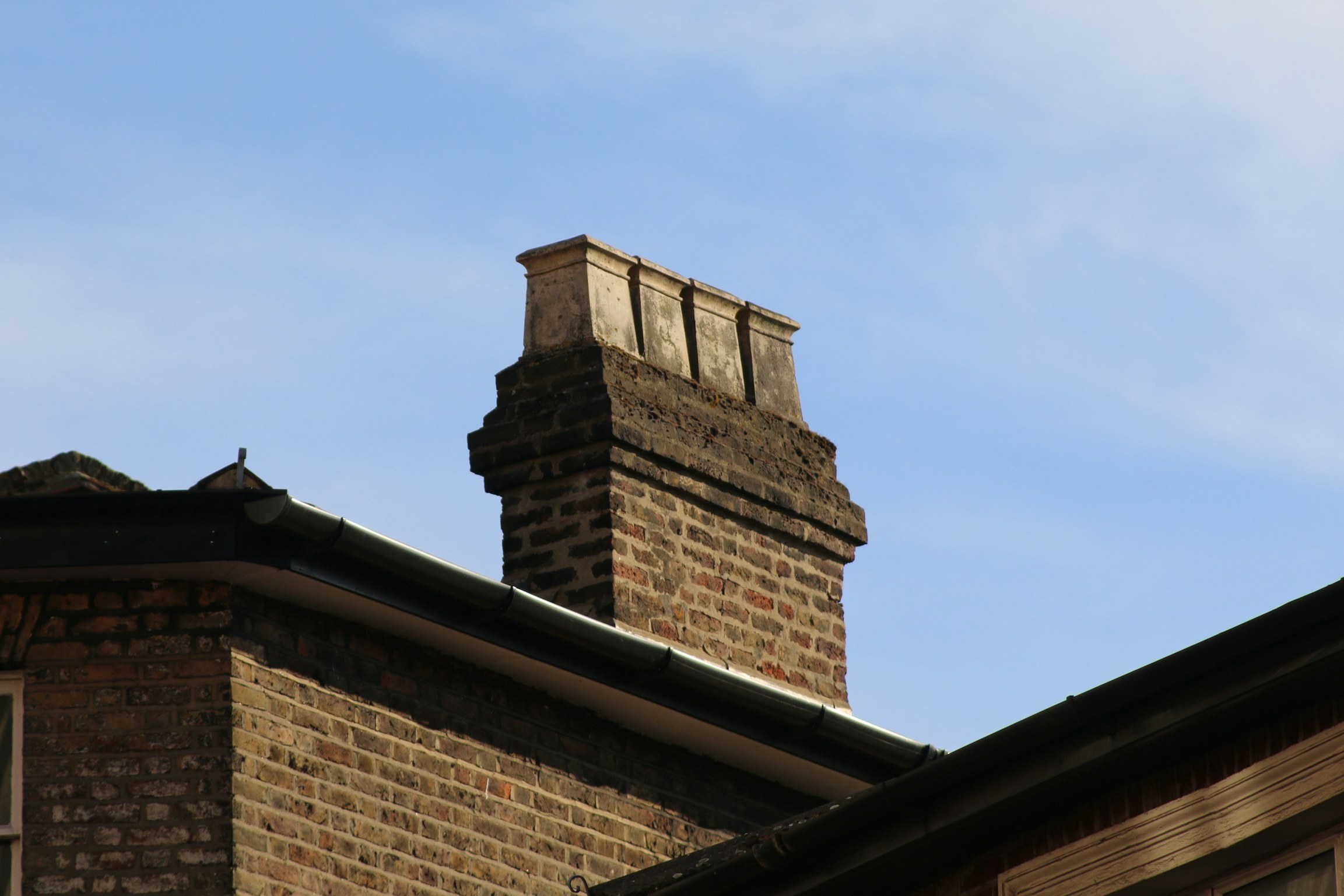 Brick chimney stack with pots against the sky