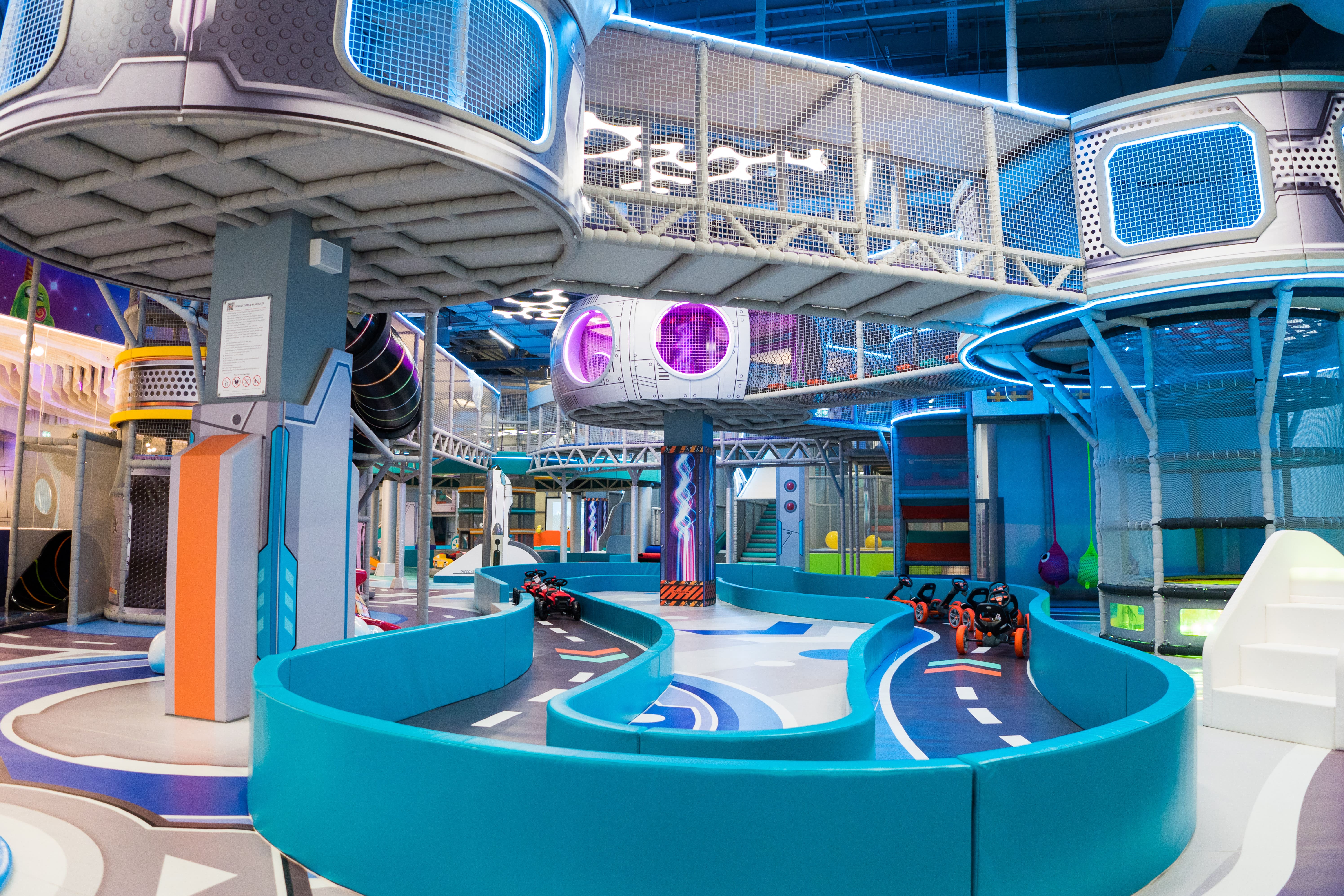 Space-themed indoor entertainment with go-kart track and climbing structures