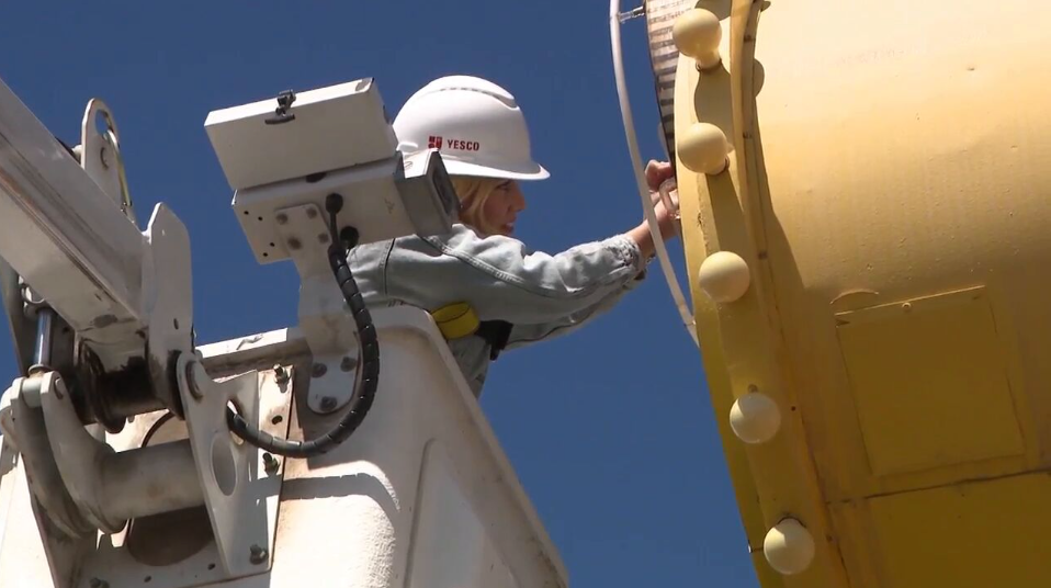 Sign technician performing professional maintenance work on outdoor commercial sign