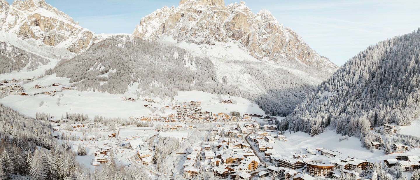 The charming village of Corvara with Dolomite peaks behind