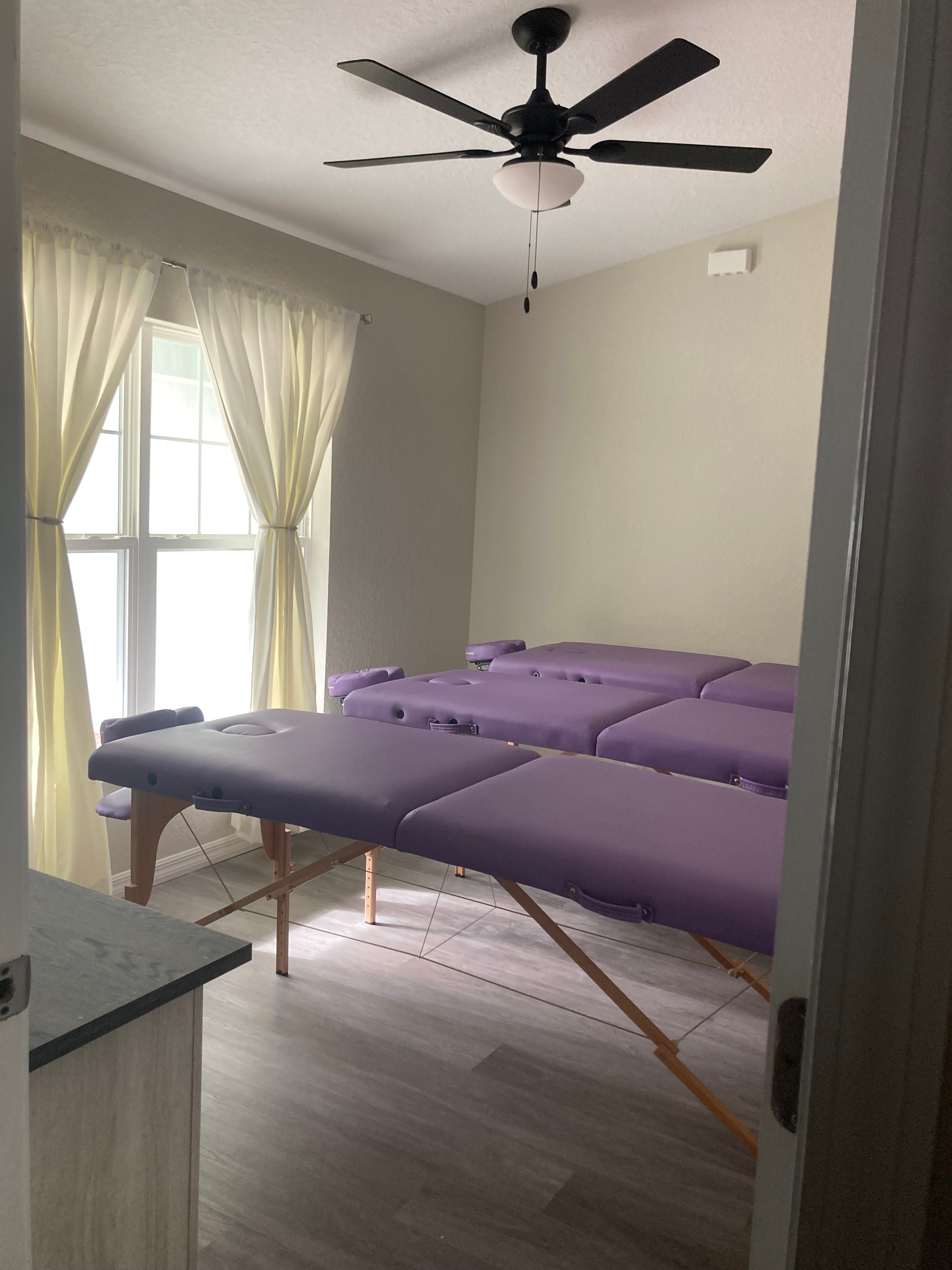 Wide view of the Life Flow Spinal Group studio with multiple lavender treatment tables