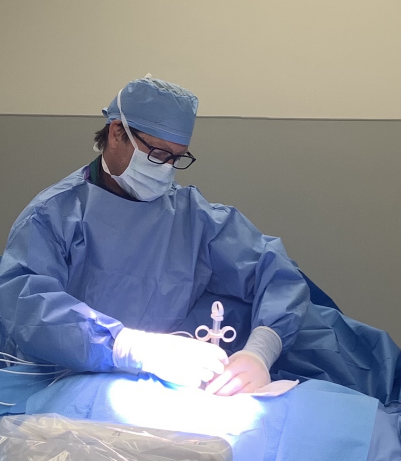 Brian Fleeman, CRNA, performing a procedure in full surgical attire