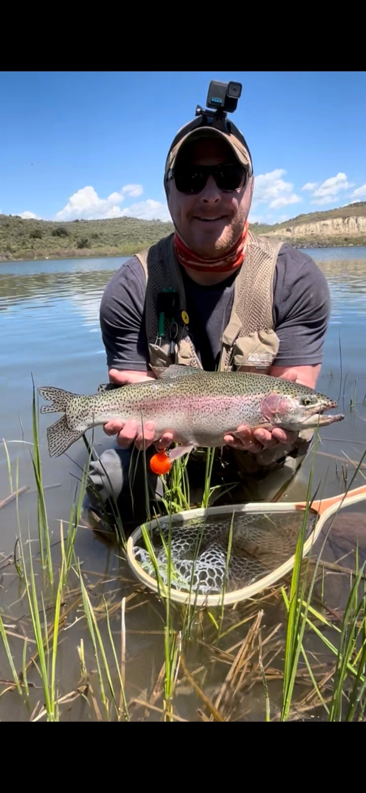 Camp Hero participant with rainbow trout catch by the lake