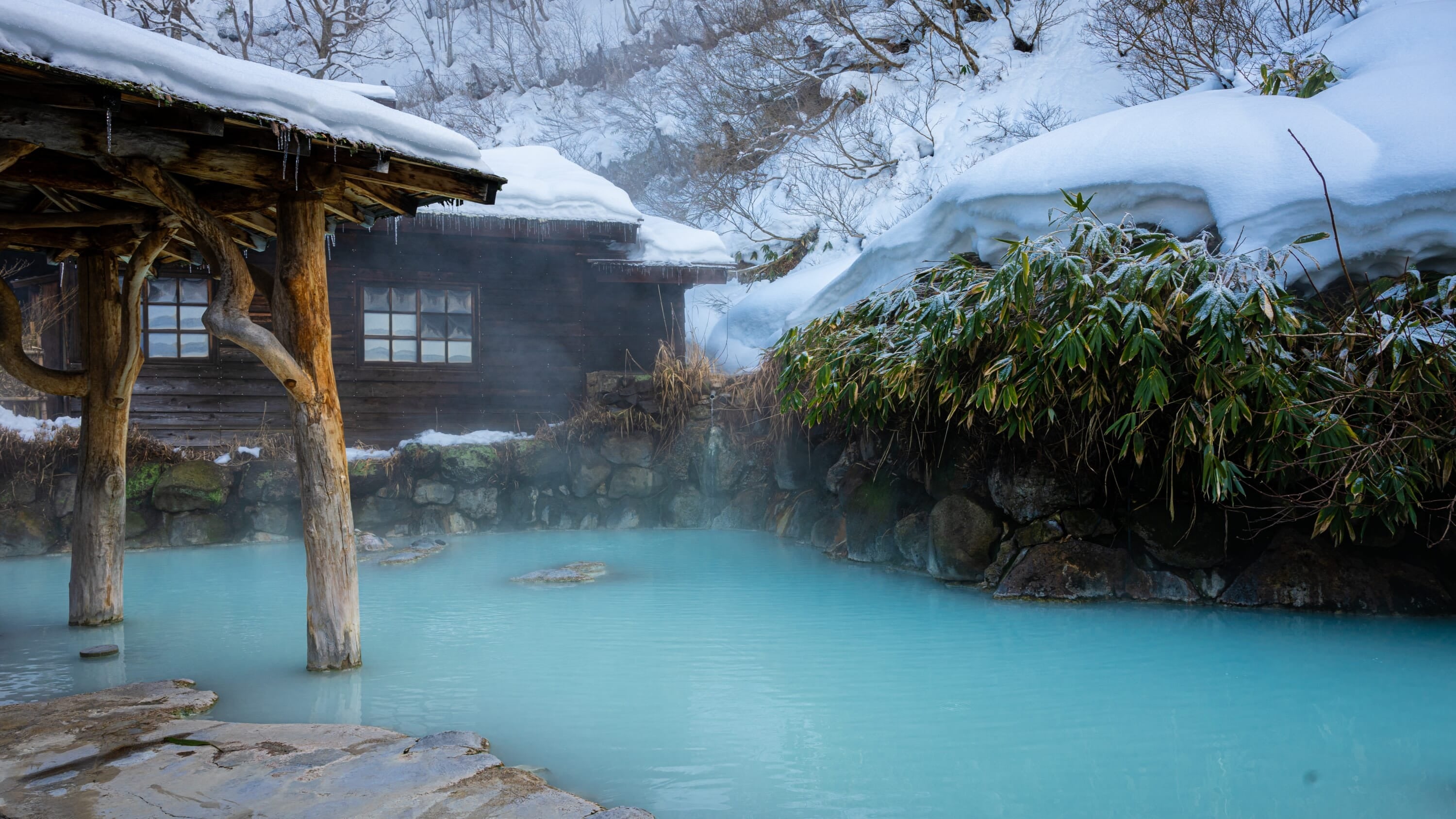 Traditional Japanese onsen hot spring bath in winter snow setting