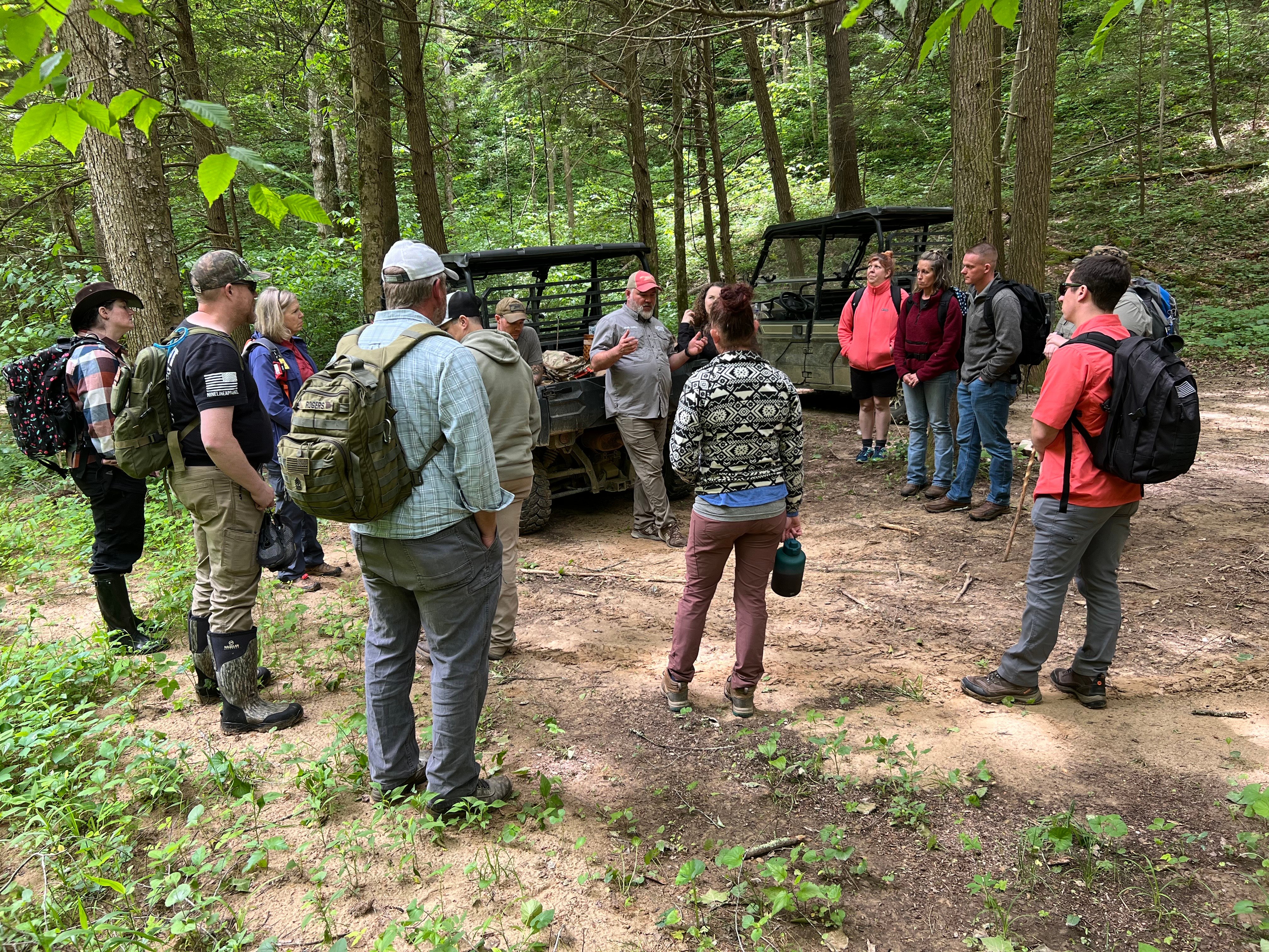 Camp Hero nature immersion program - group gathered in forest with ATVs during outdoor therapy