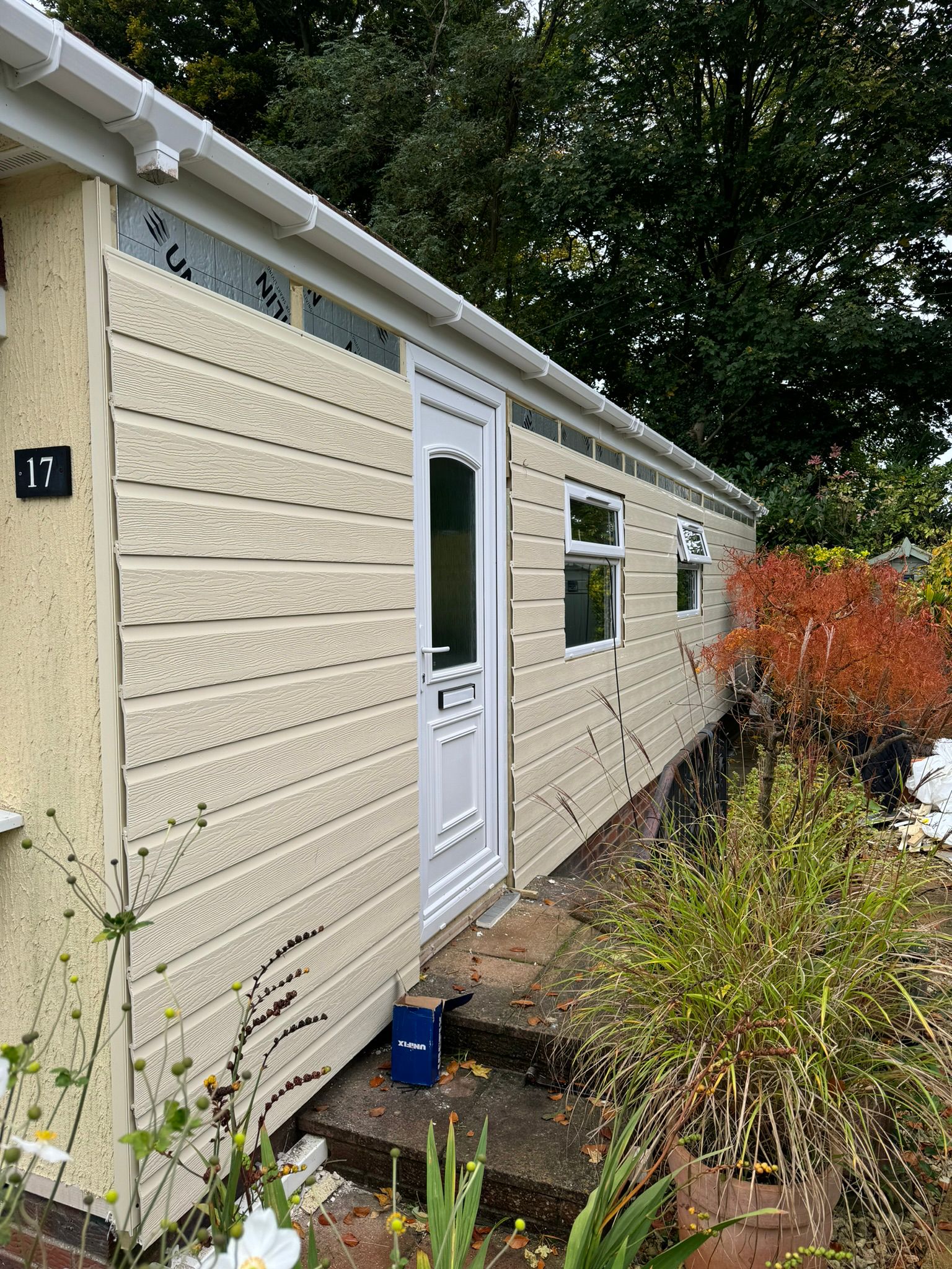 Completed full side cladding on park home number 17 with new cream boards, door, windows and garden