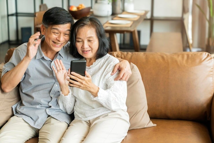 Elderly couple happily using smartphone for healthcare