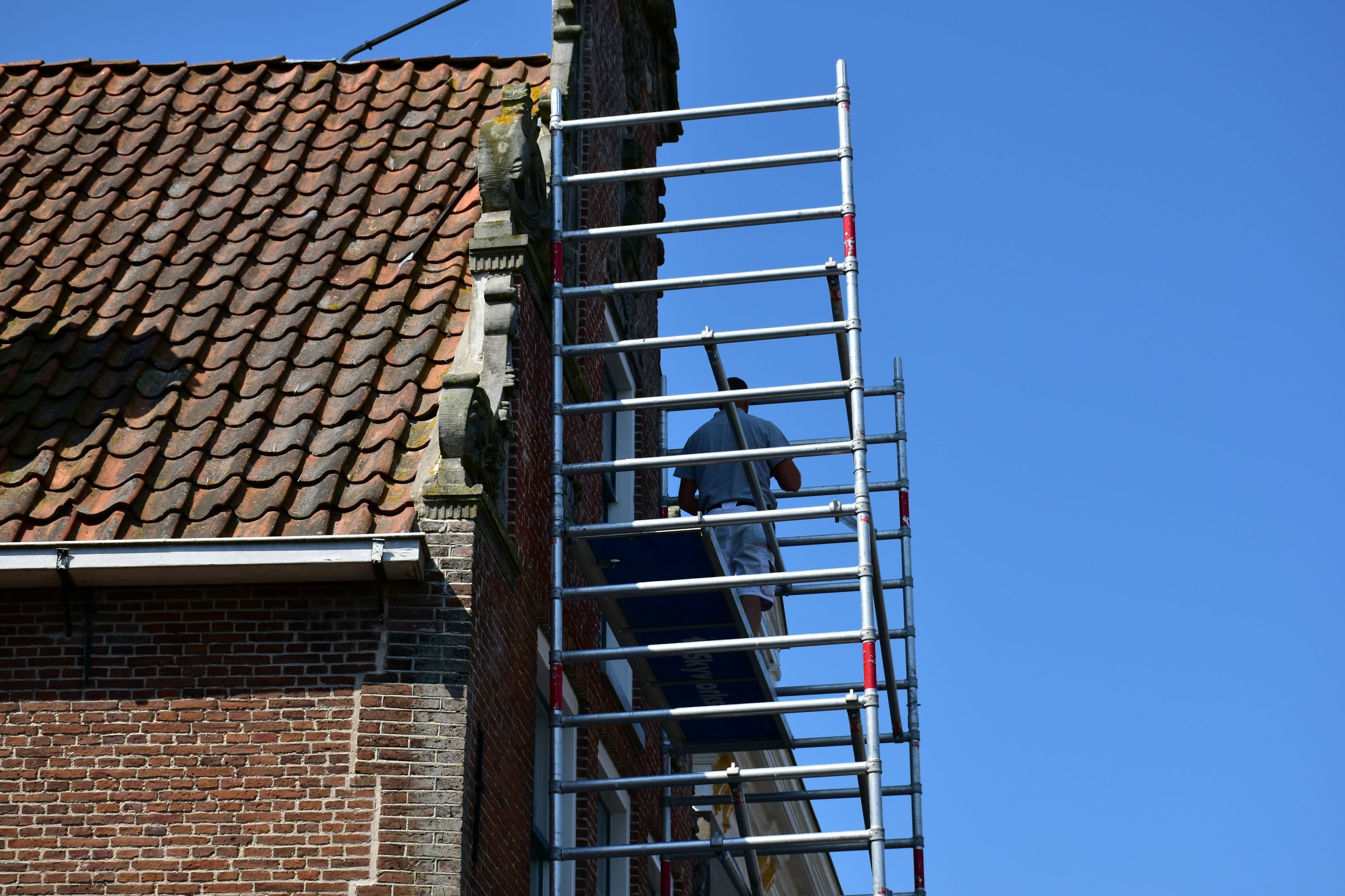 Scaffold access to a tiled roof on a brick house