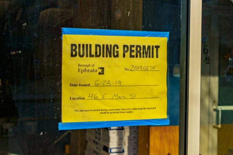 Professional construction permit sign posted at building site showing permit information