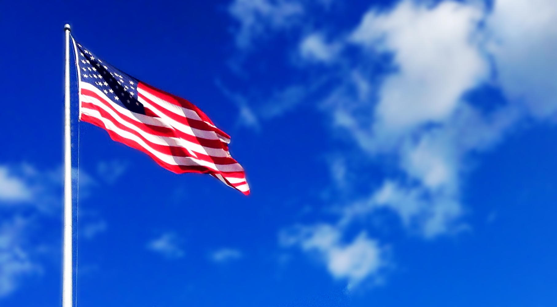 American flag waving against blue sky