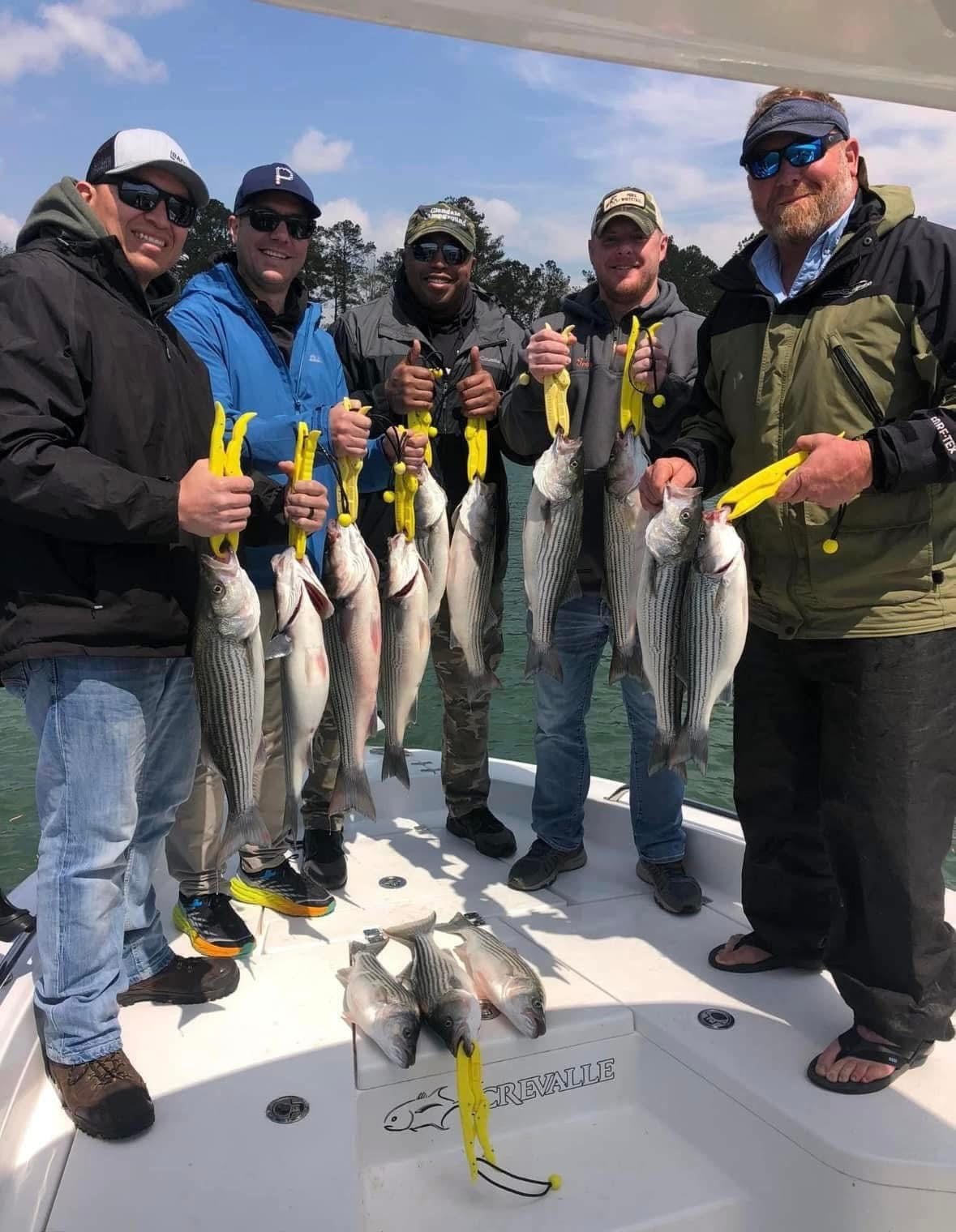 Camp Hero fishing trip - group holding striped bass catch on a Crevalle boat