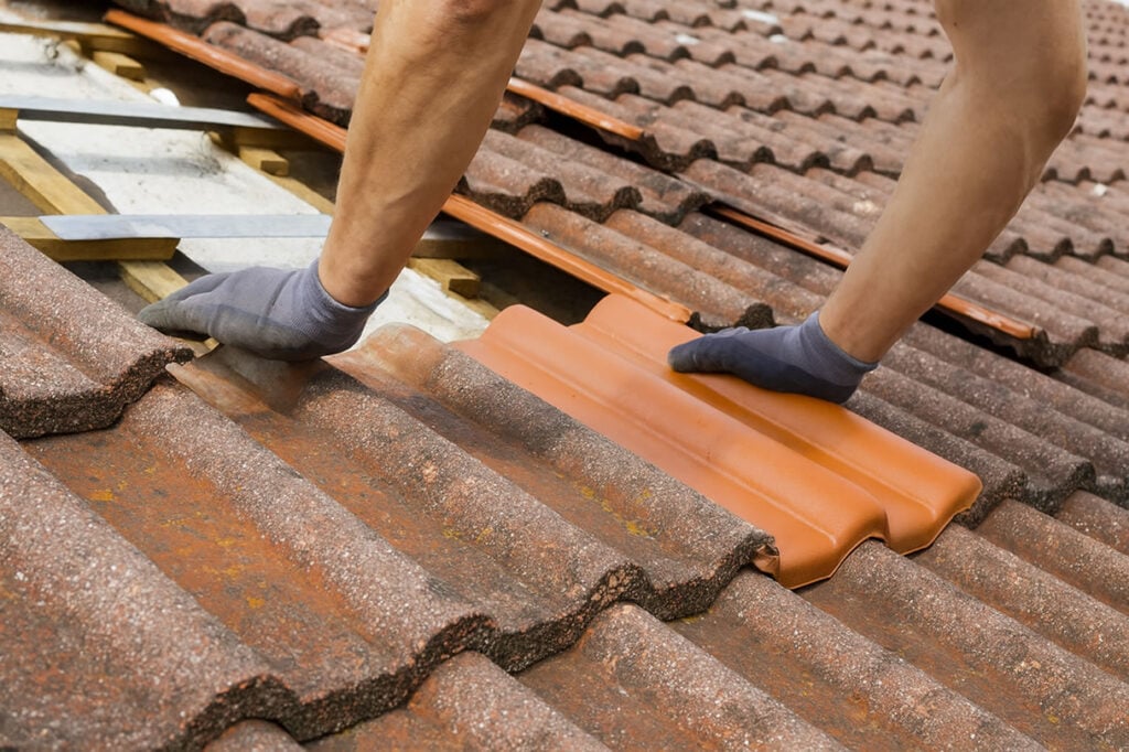 Professional roofer fitting tiles