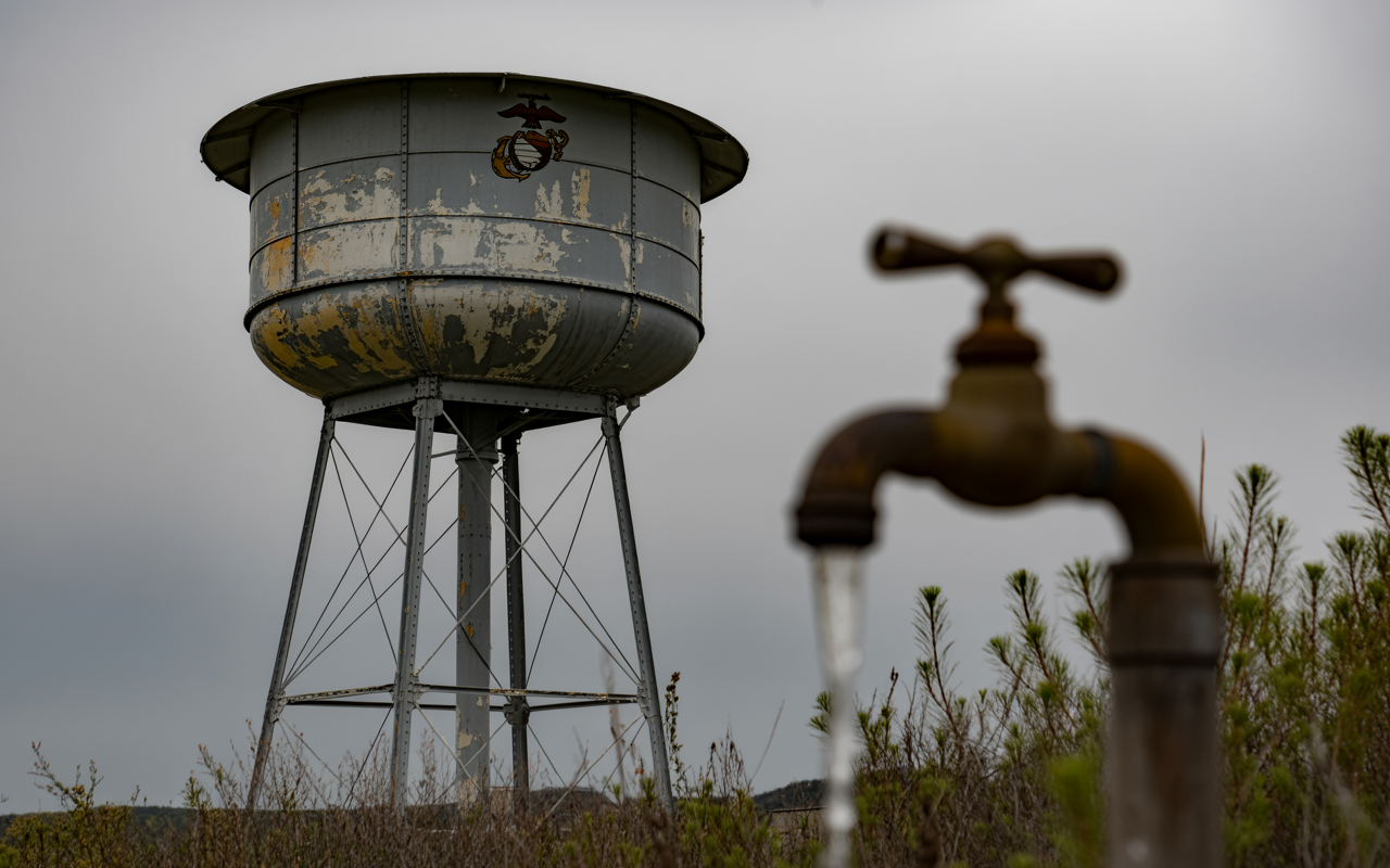 A Marine Corps base water tower and spigot representing the Camp Lejeune contaminated water claims