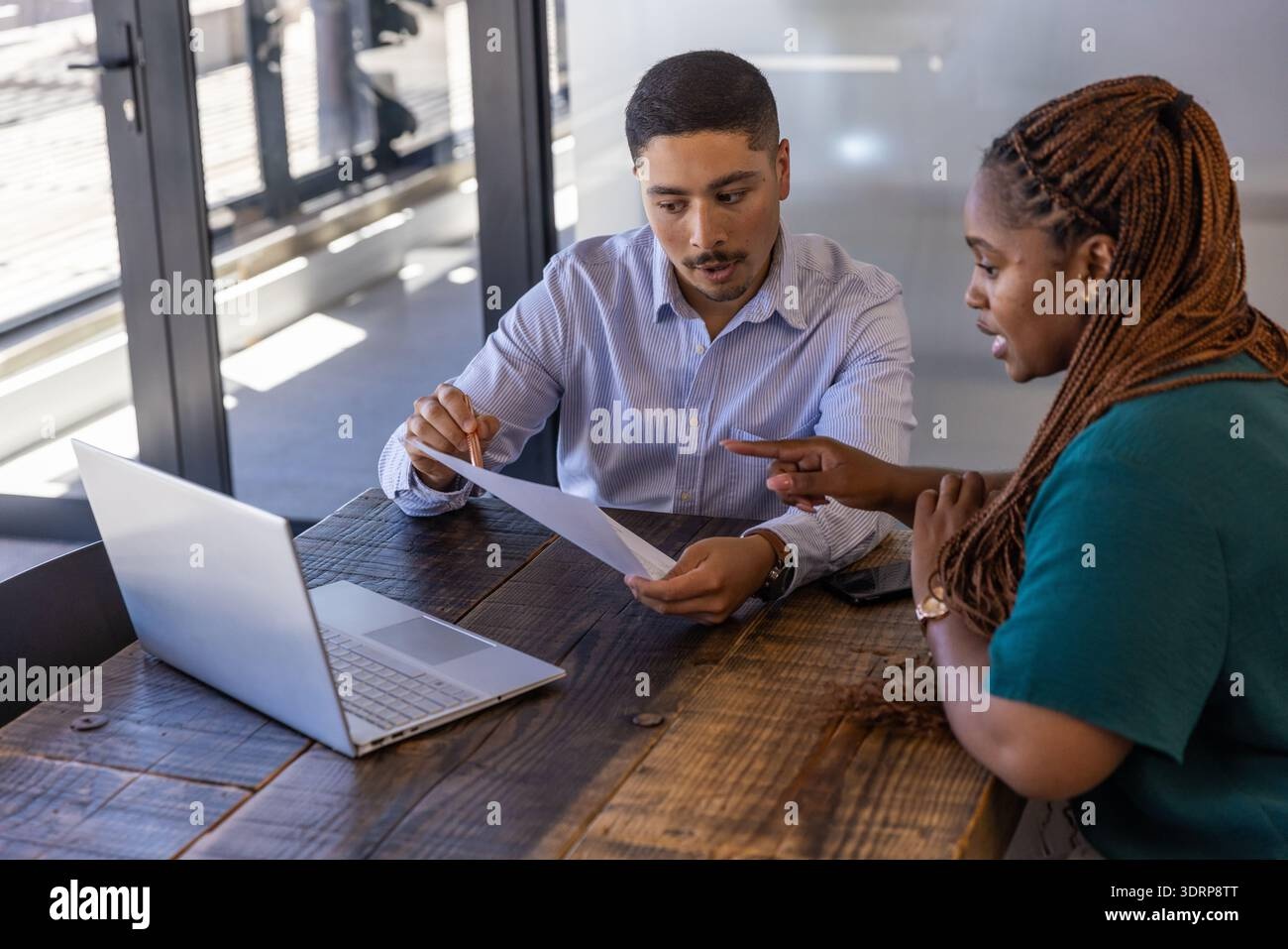 Business professionals reviewing documents and collaborating on laptops