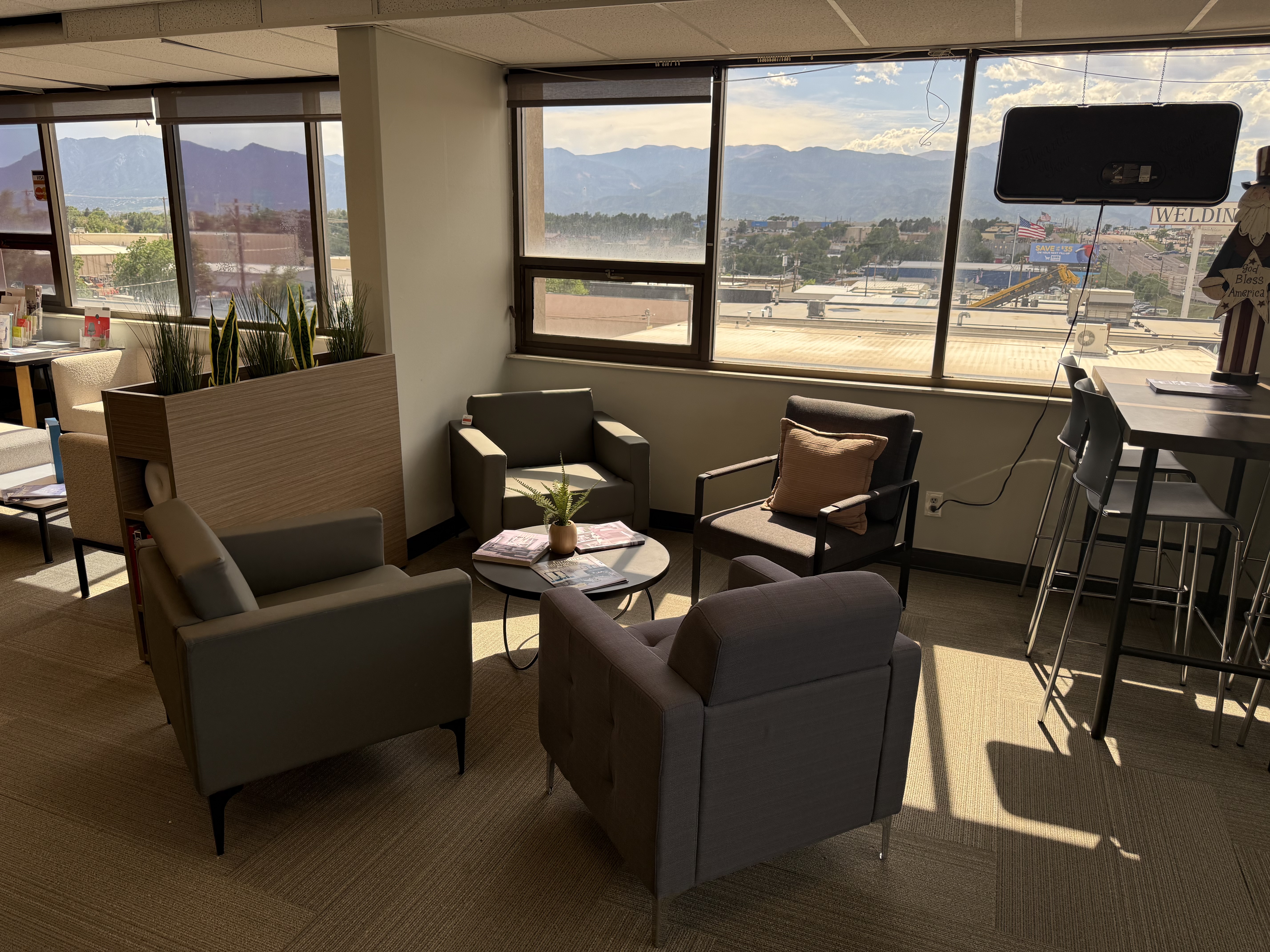 Lounge seating area with mountain views through the showroom windows