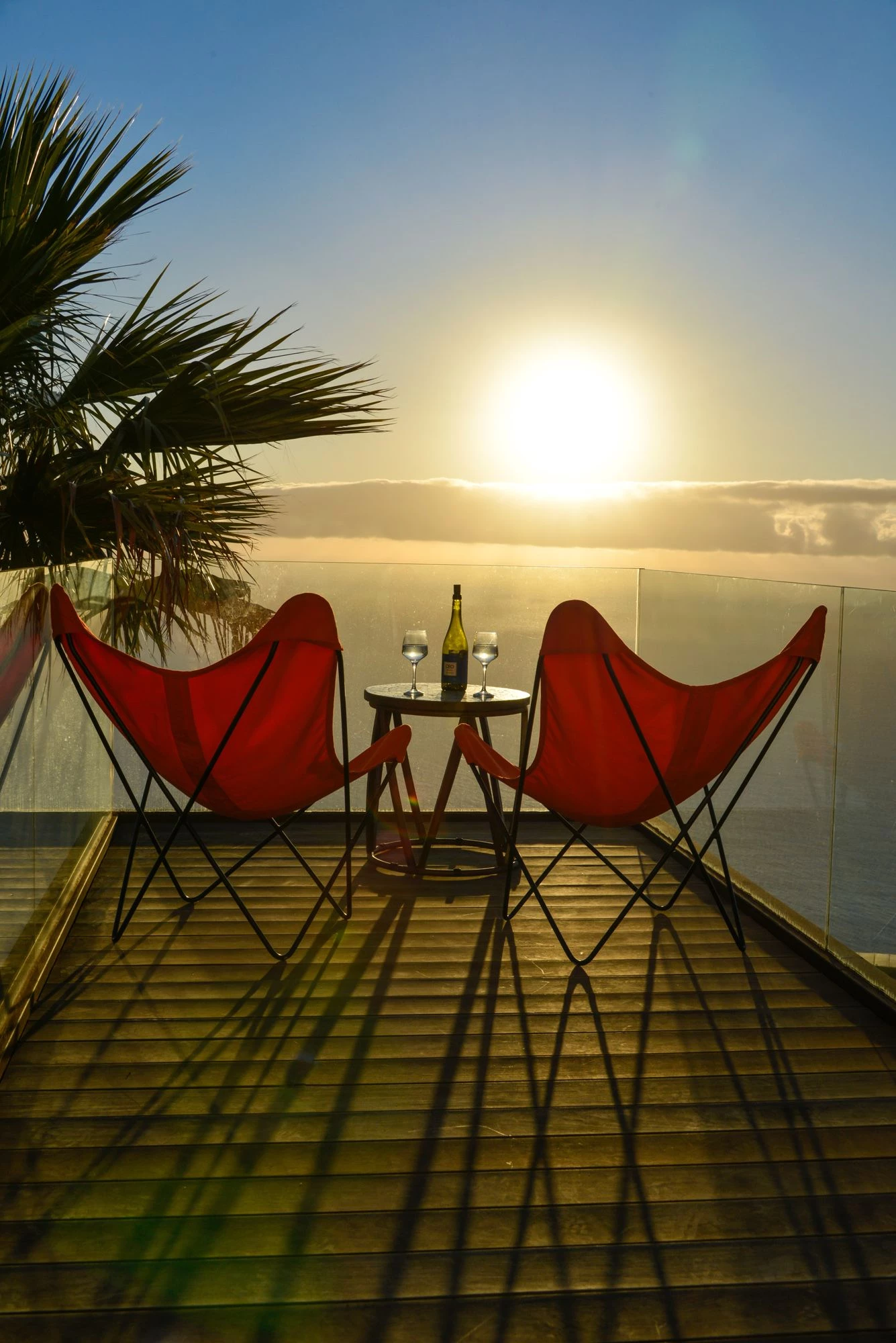 Golden sunset from terrace with red Adirondack chairs